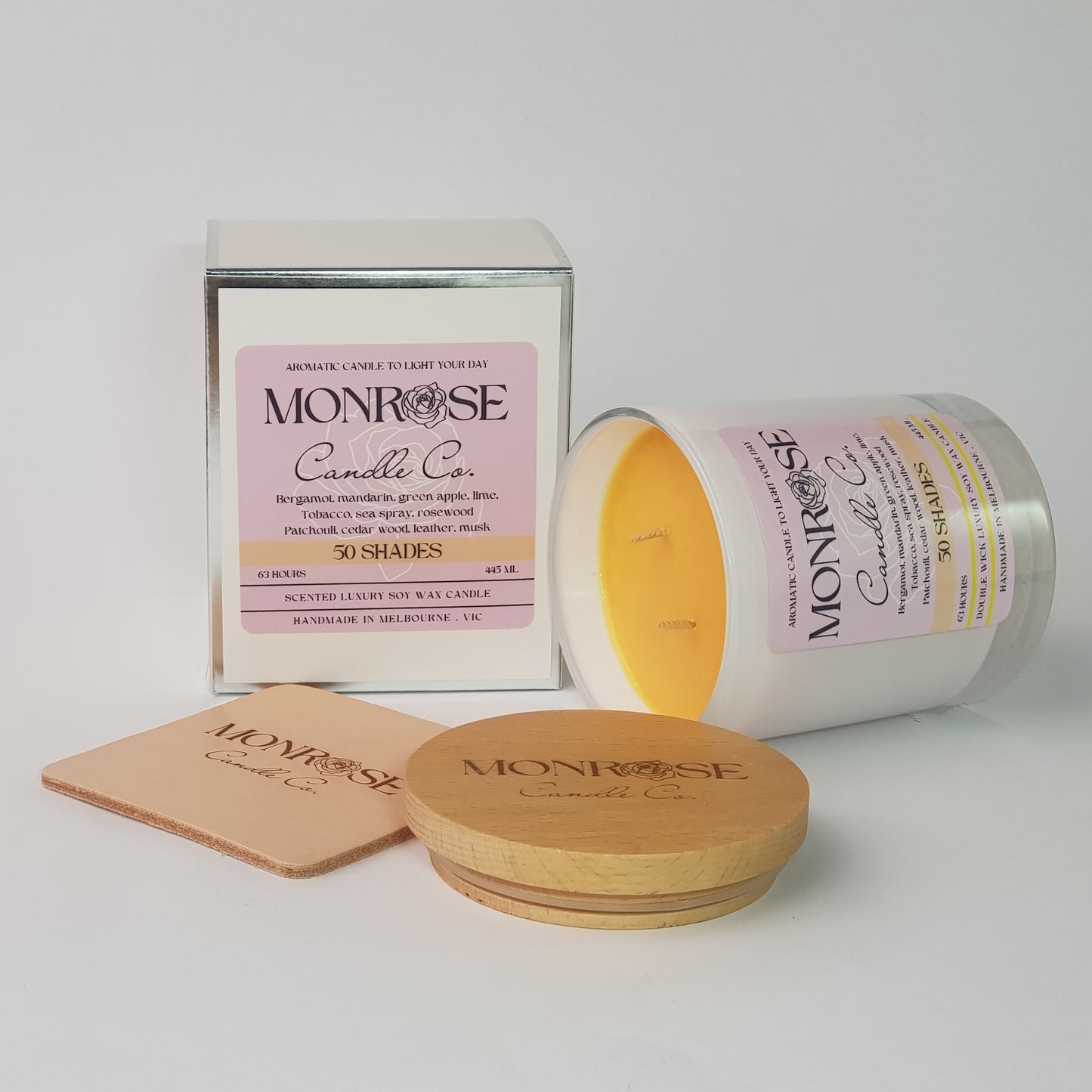 Side view of a white jar candle with "50 Shades" fragrance and a cotton wick, containing 395 grams of soy wax and offering 63 hours of burn time.