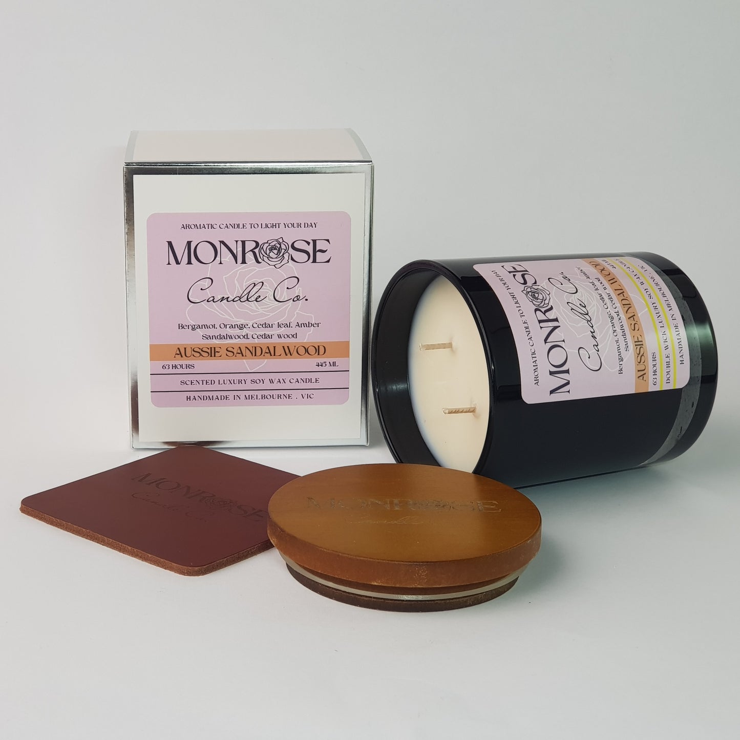 Side view of a black jar candle with "Australian Sandalwood" fragrance and two cotton wicks, containing 395 grams of soy wax and offering 63 hours of burn time.