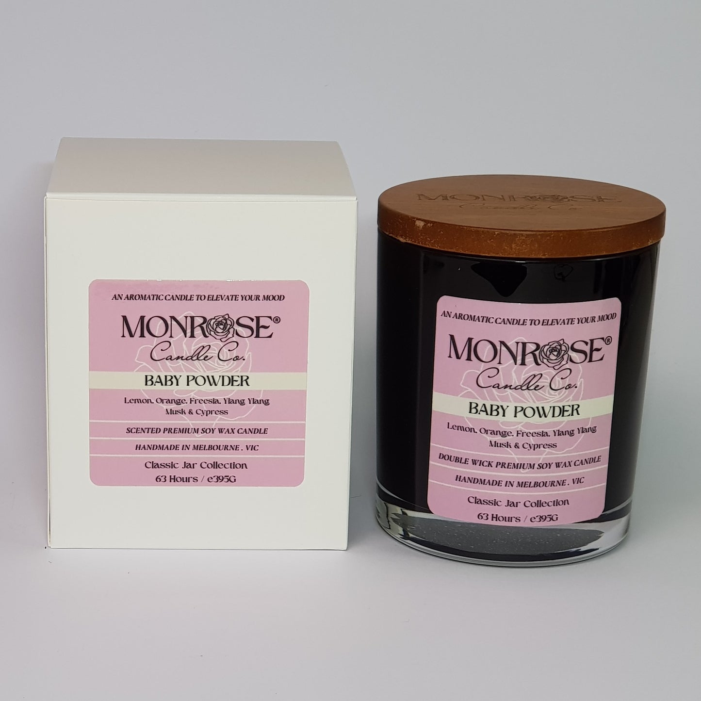 Front view of a black jar candle with "Baby powder" fragrance and double cotton wicks, containing 395 grams of soy wax and offering 63 hours of burn time.