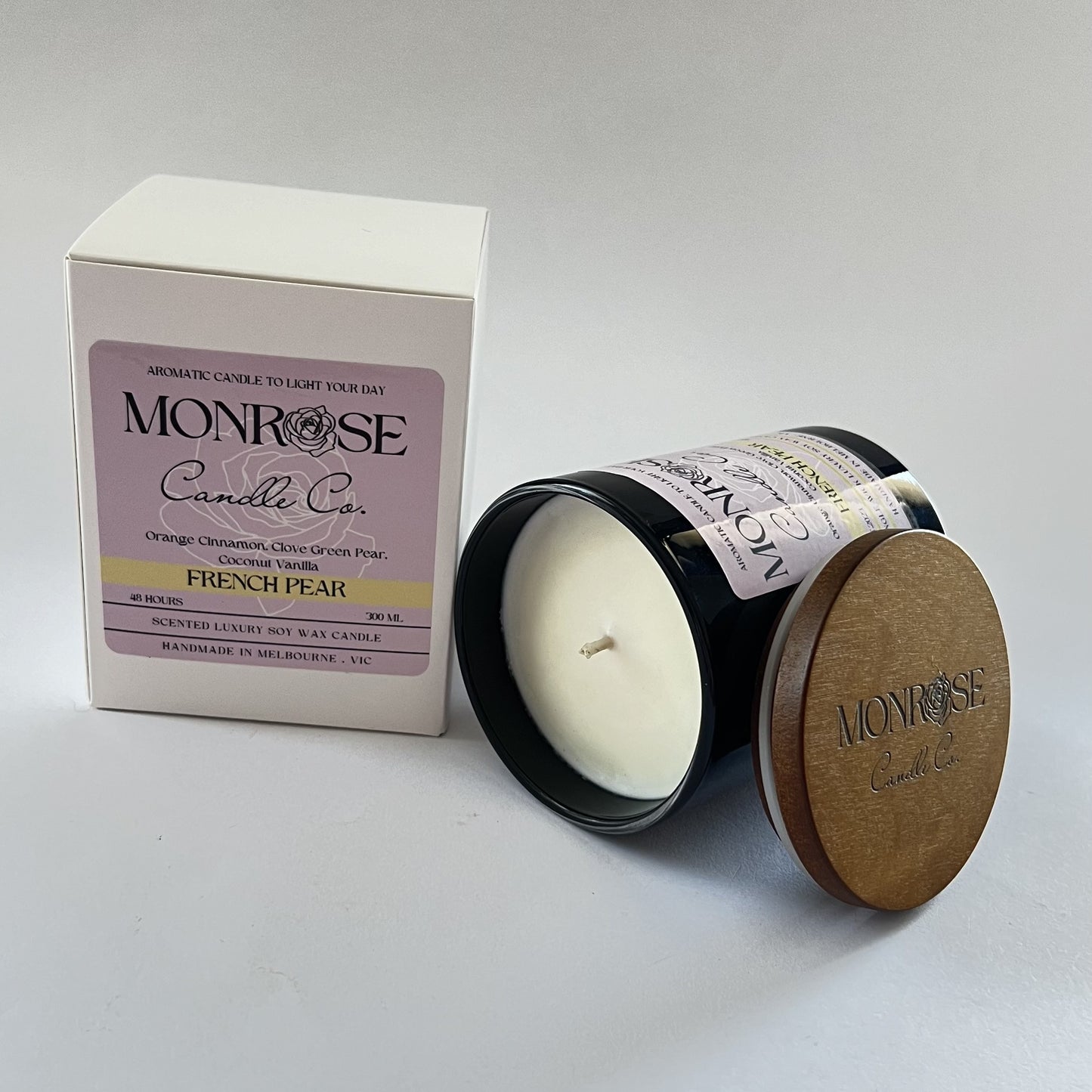 "Side view of a black jar candle with French pear fragrance and double cotton wicks, containing 265 grams of soy wax and offering 48 hours of burn time."