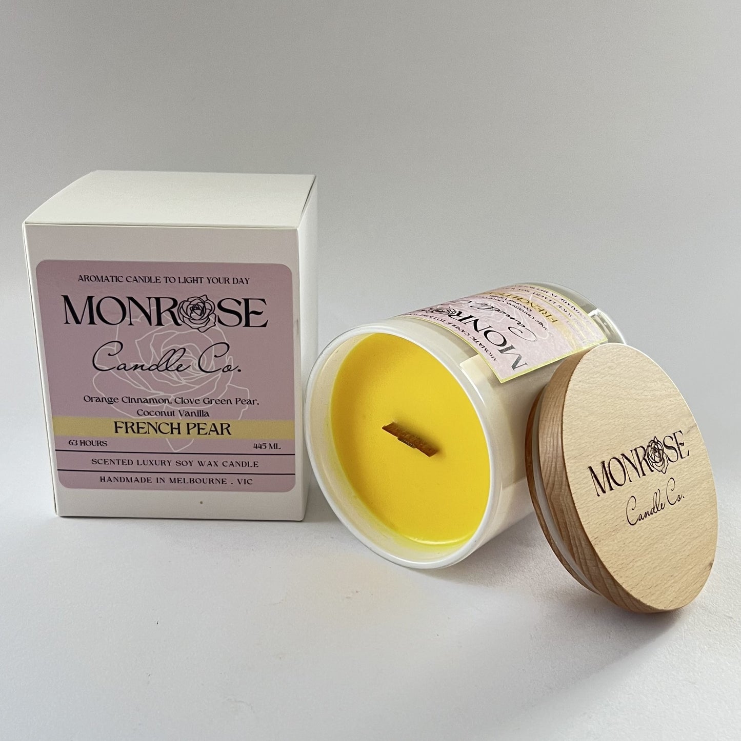 Side view of a White jar candle with "French pear" fragrance and wood wick, containing 395 grams of soy wax and offering 63 hours of burn time.