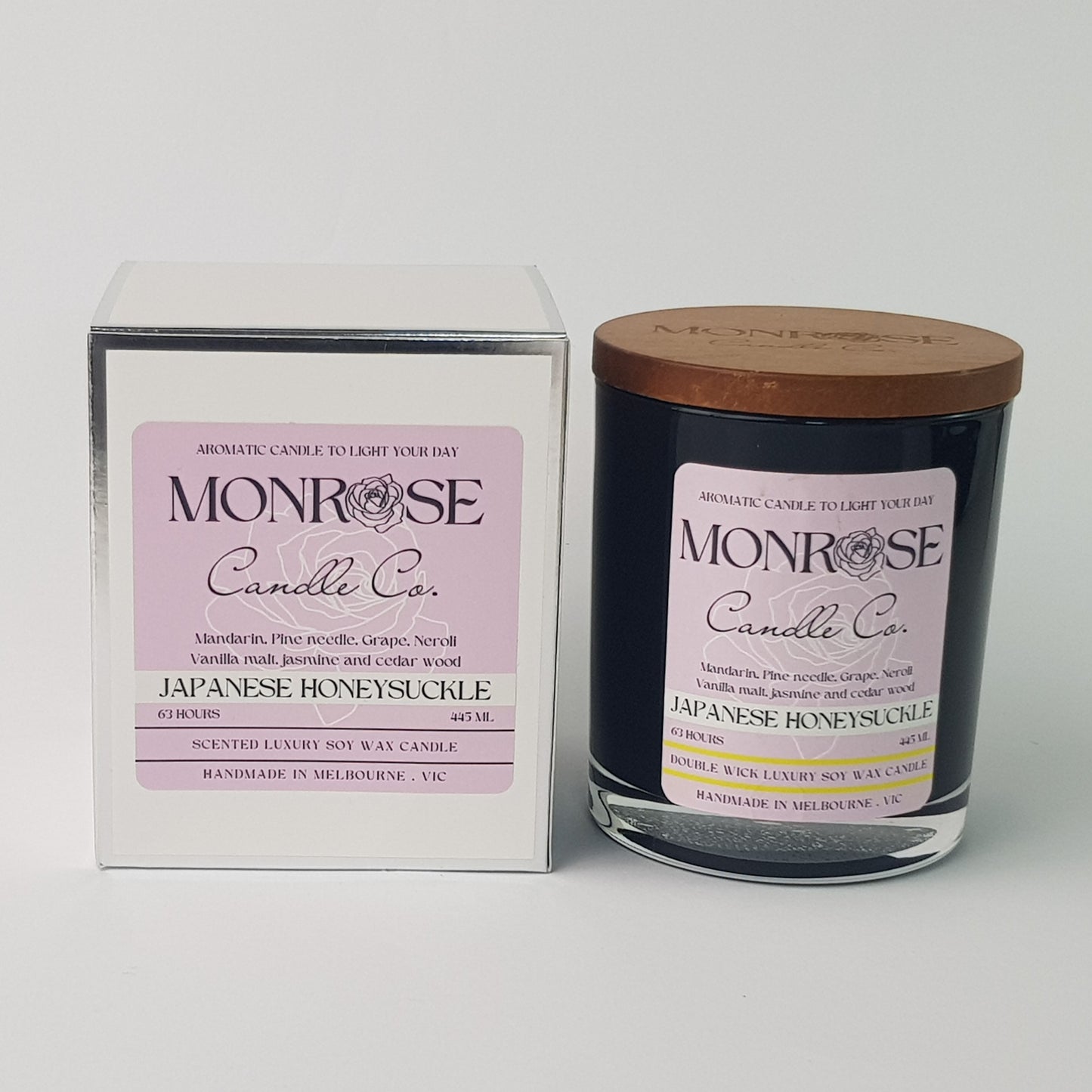 Front view of a black jar candle with "Japanese honeysuckle" fragrance and a cotton wick, containing 395 grams of soy wax and offering 63 hours of burn time.