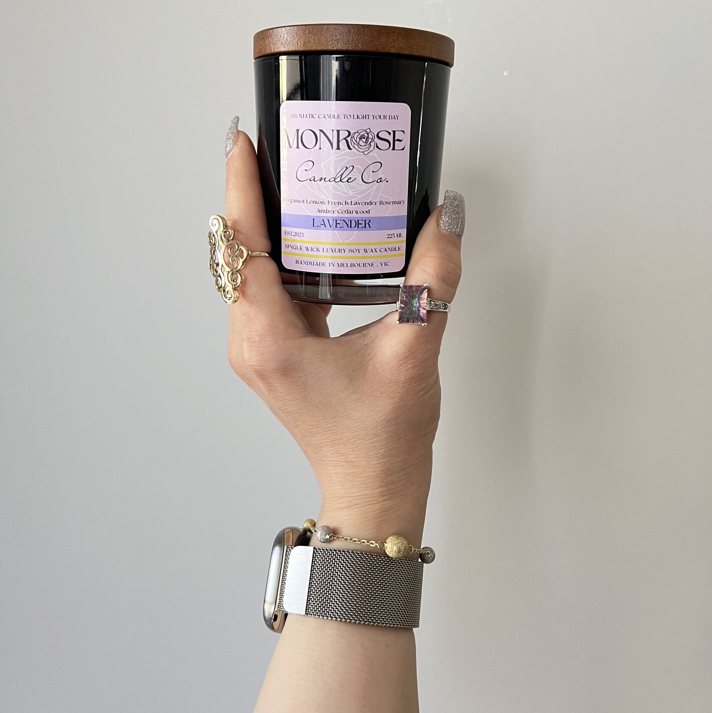 Front view of a black jar candle with "Lavender" fragrance and a cotton wick, containing 185 grams of soy wax and offering 33 hours of burn time.