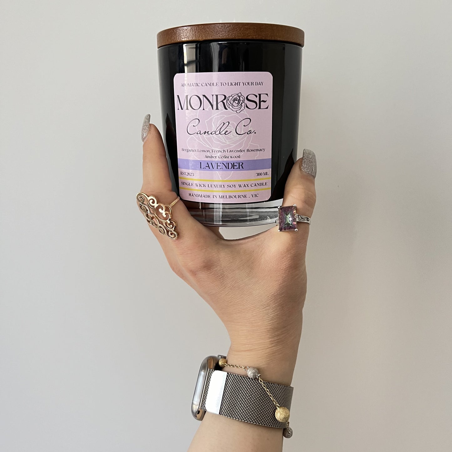 Front view of a container candle with "Lavender" fragrance in black glass jar and a cotton wick, containing 265 grams of soy wax and offering 48 hours of burn time.