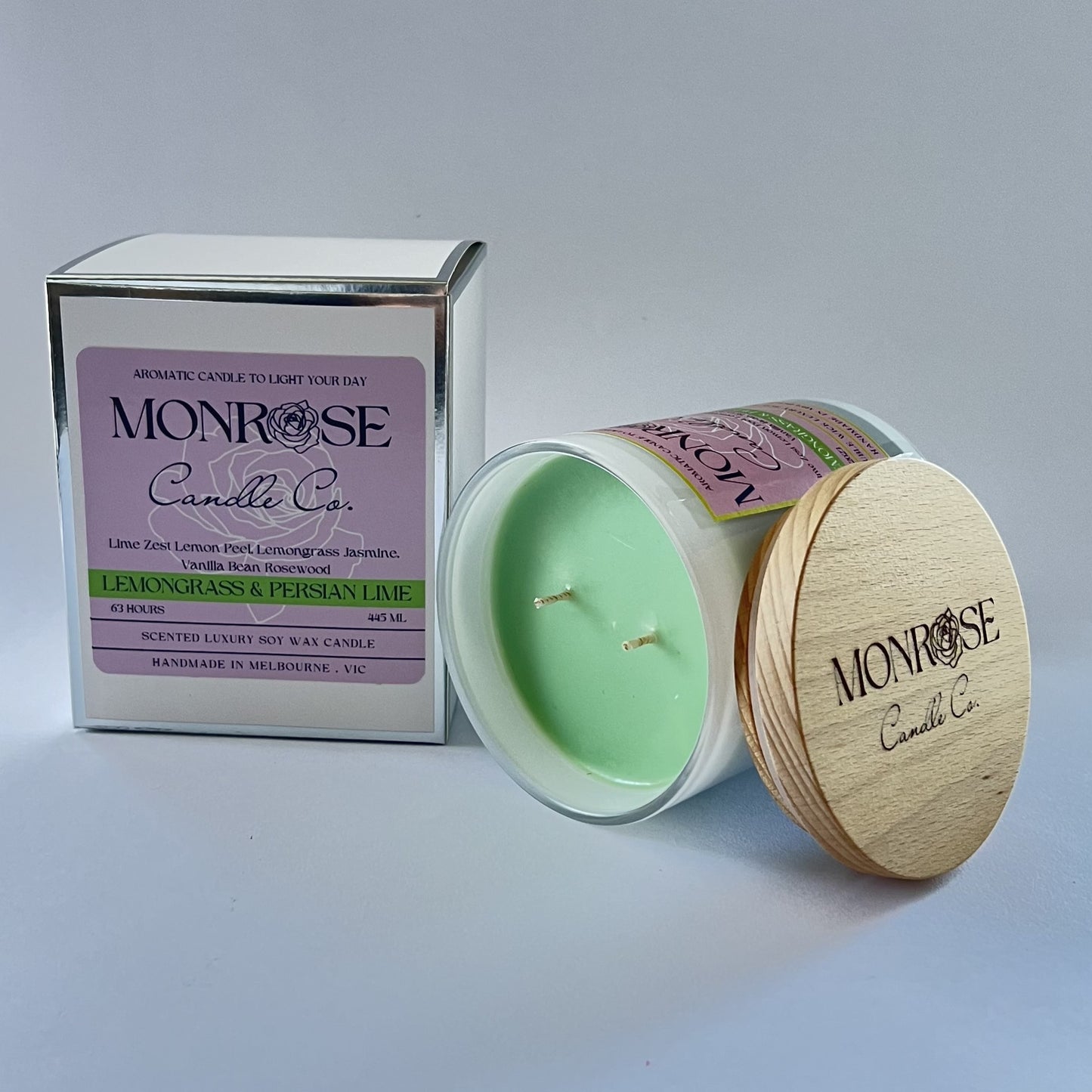 Side view of a white jar candle with "lemongrass & Persian lime" fragrance and double cotton wicks, containing 395 grams of soy wax and offering 63 hours of burn time.