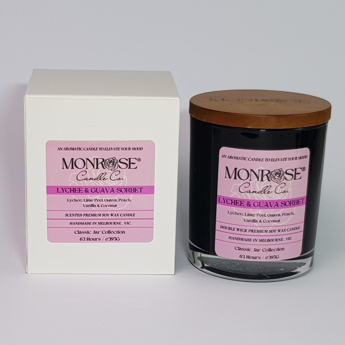 Front view of a container candle with "Lychee & guava sorbet" fragrance in black glass jar and double cotton wicks, containing 395 grams of soy wax and offering 63 hours of burn time.