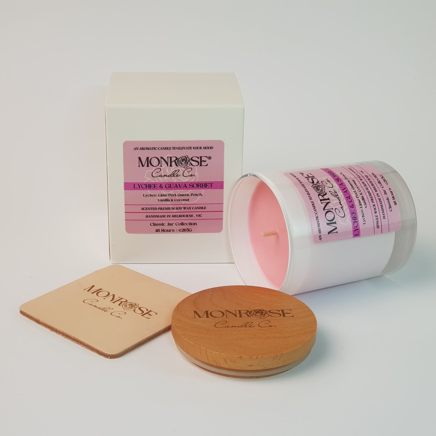 Side view of a container candle with "Lychee & guava sorbet" fragrance in white glass jar and a cotton wick, containing 265 grams of soy wax and offering 48 hours of burn time.