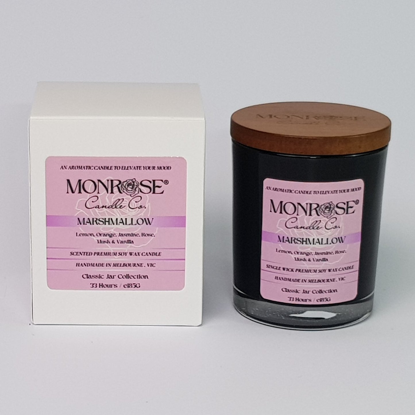 Front view of a container candle with "Marshmallow" fragrance in black glass jar and a cotton wick, containing 185 grams of soy wax and offering 33 hours of burn time.