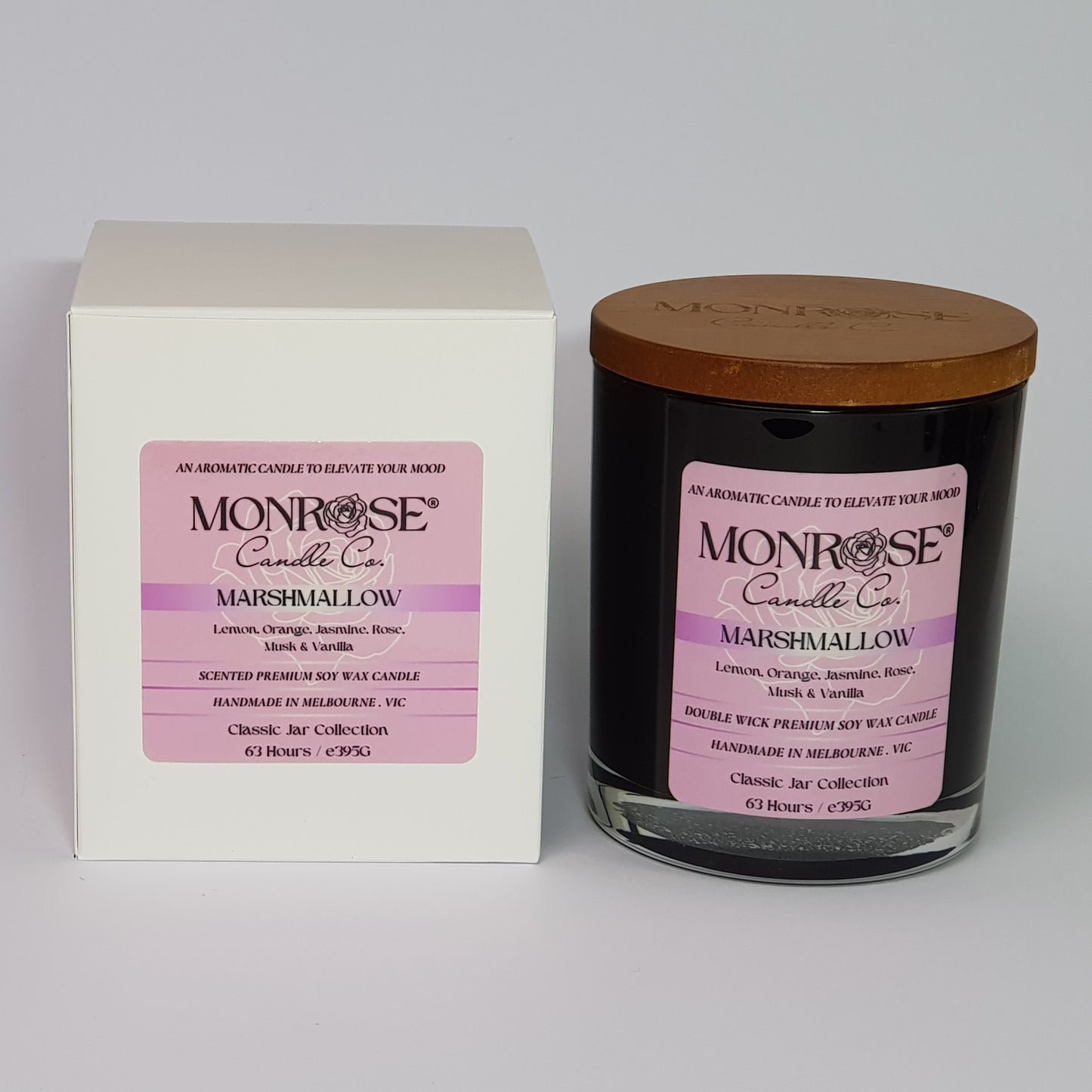 Front view of a container candle with "Marshmallow" fragrance in black glass jar and a cotton wick, containing 395 grams of soy wax and offering 63 hours of burn time.
