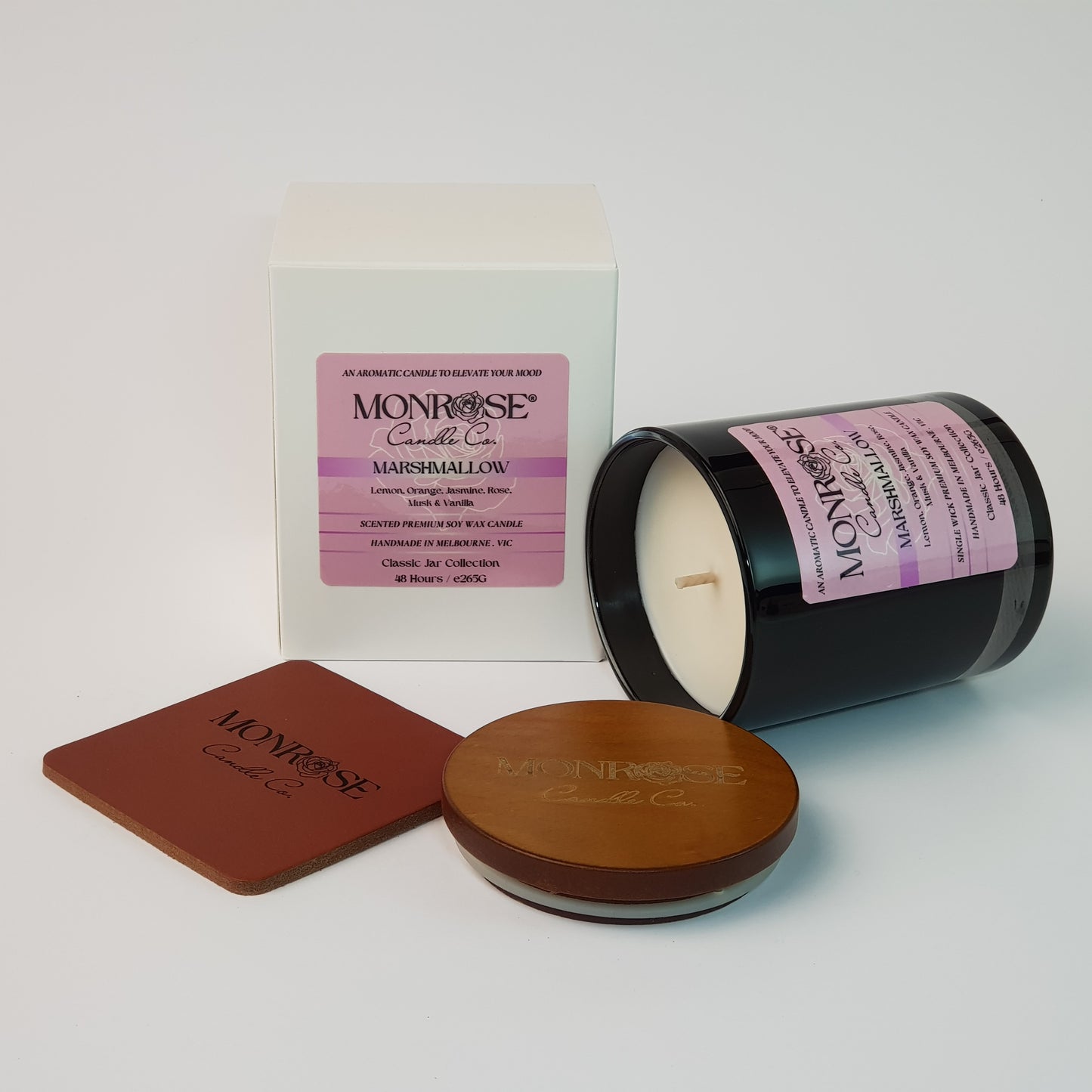 Side view of a container candle with "Marshmallow" fragrance in black glass jar and a cotton wick, containing 265 grams of soy wax and offering 48 hours of burn time.