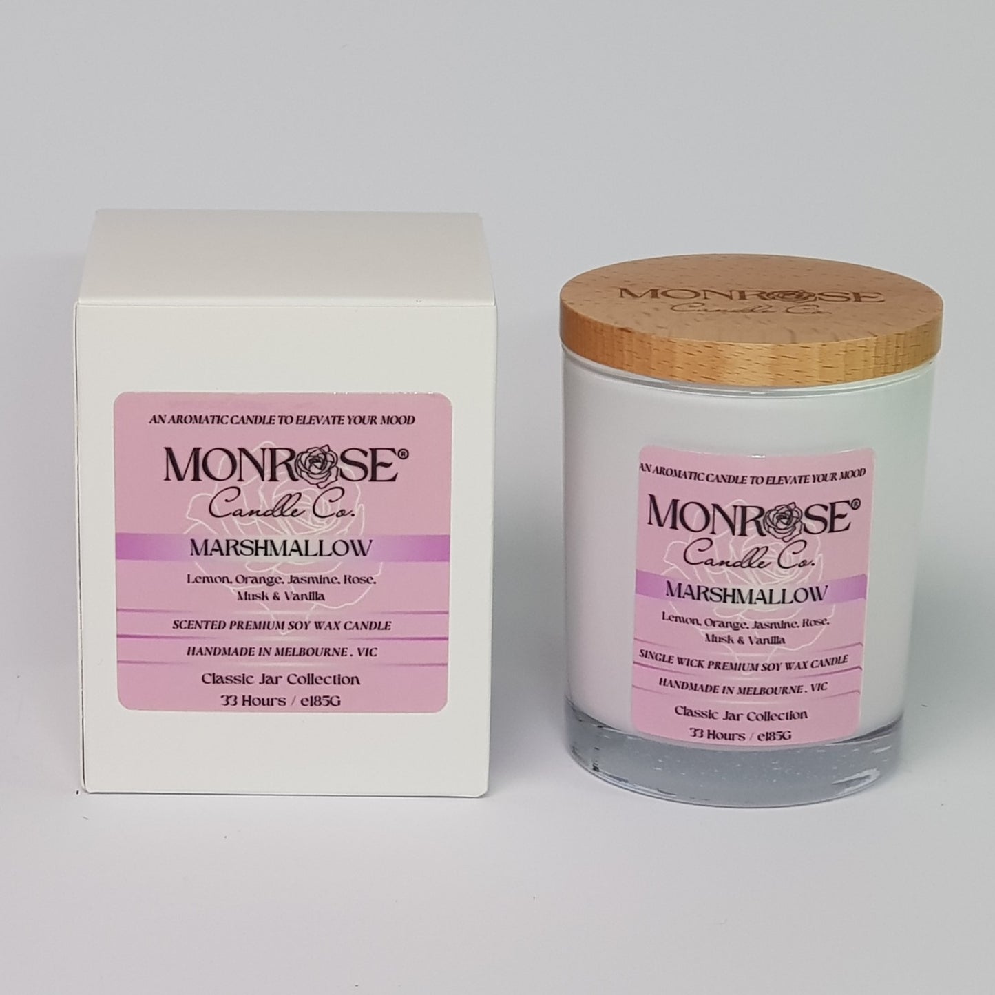 Front view of a container candle with "Marshmallow" fragrance in white glass jar and a cotton wick, containing 185 grams of soy wax and offering 33 hours of burn time.