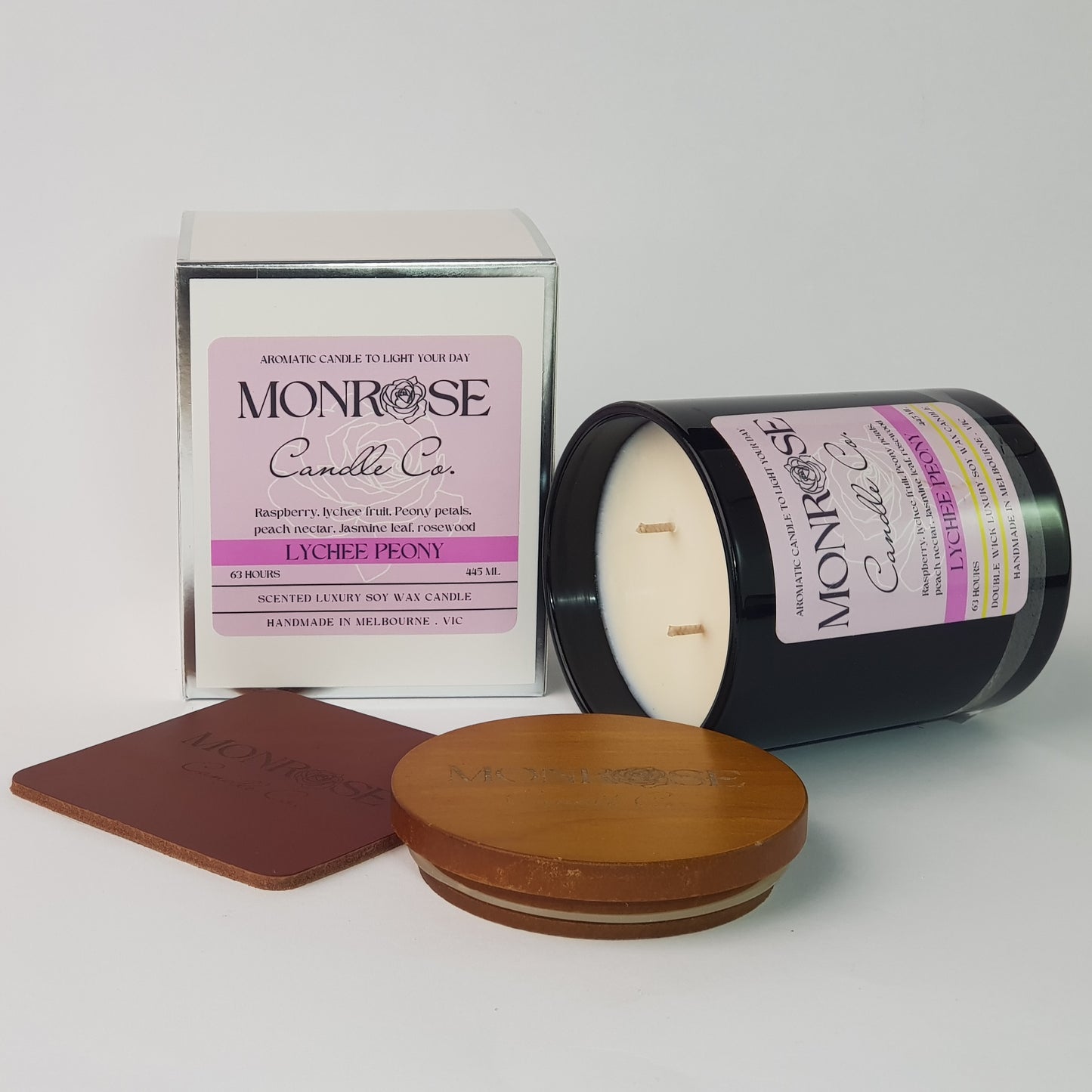 Side view of a black jar candle with "Pink champagne & exotic fruits" fragrance and double cotton wick, containing 395 grams of soy wax and offering 63 hours of burn time.