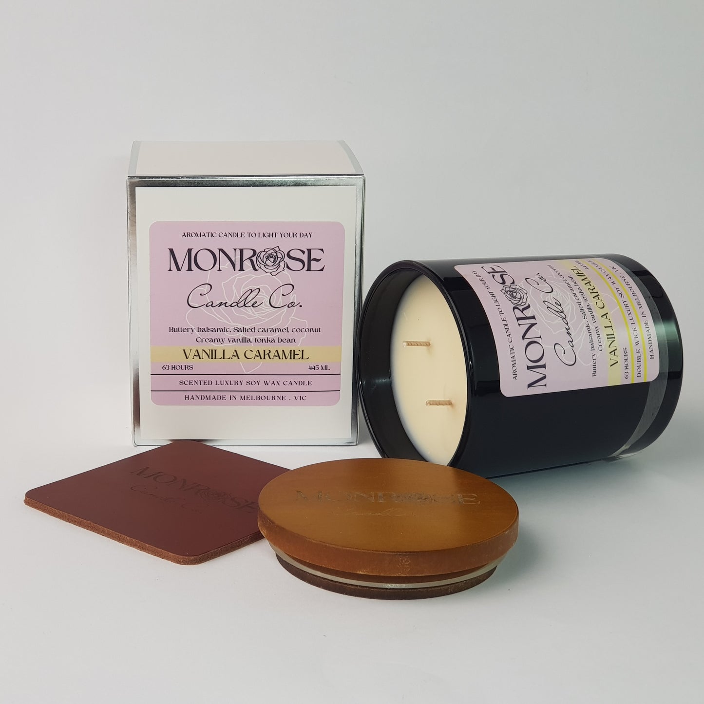 Side view of a black jar candle with "Vanilla caramel" fragrance and double cotton wicks, containing 395 grams of soy wax and offering 63 hours of burn time.