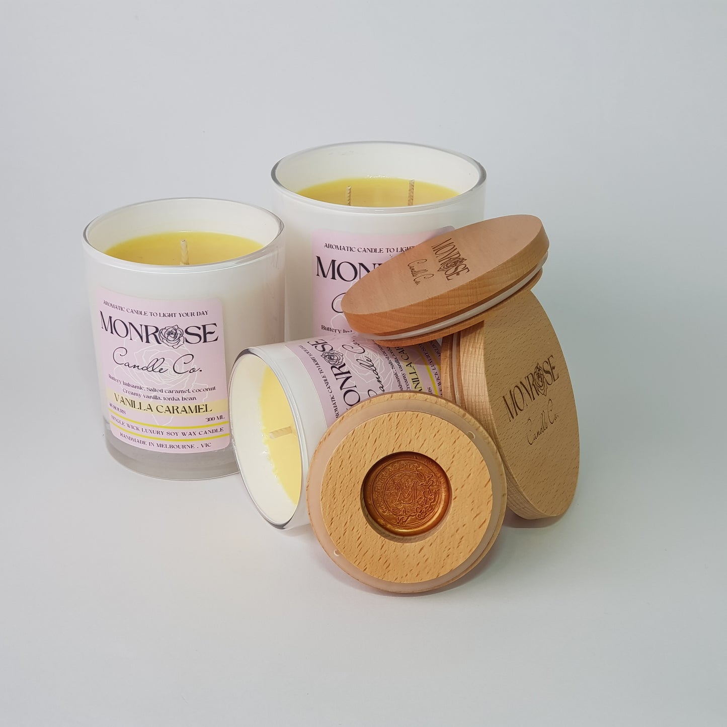 Front view of "vanilla caramel" fragrance candle collection in white jars with cotton wicks.
