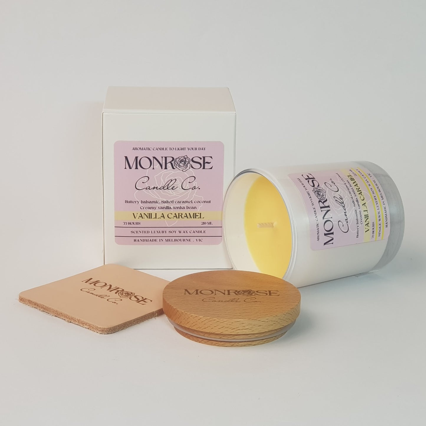 Side view of a white jar candle with "vanilla caramel" fragrance and a cotton wick, containing 185 grams of soy wax and offering 33 hours of burn time.