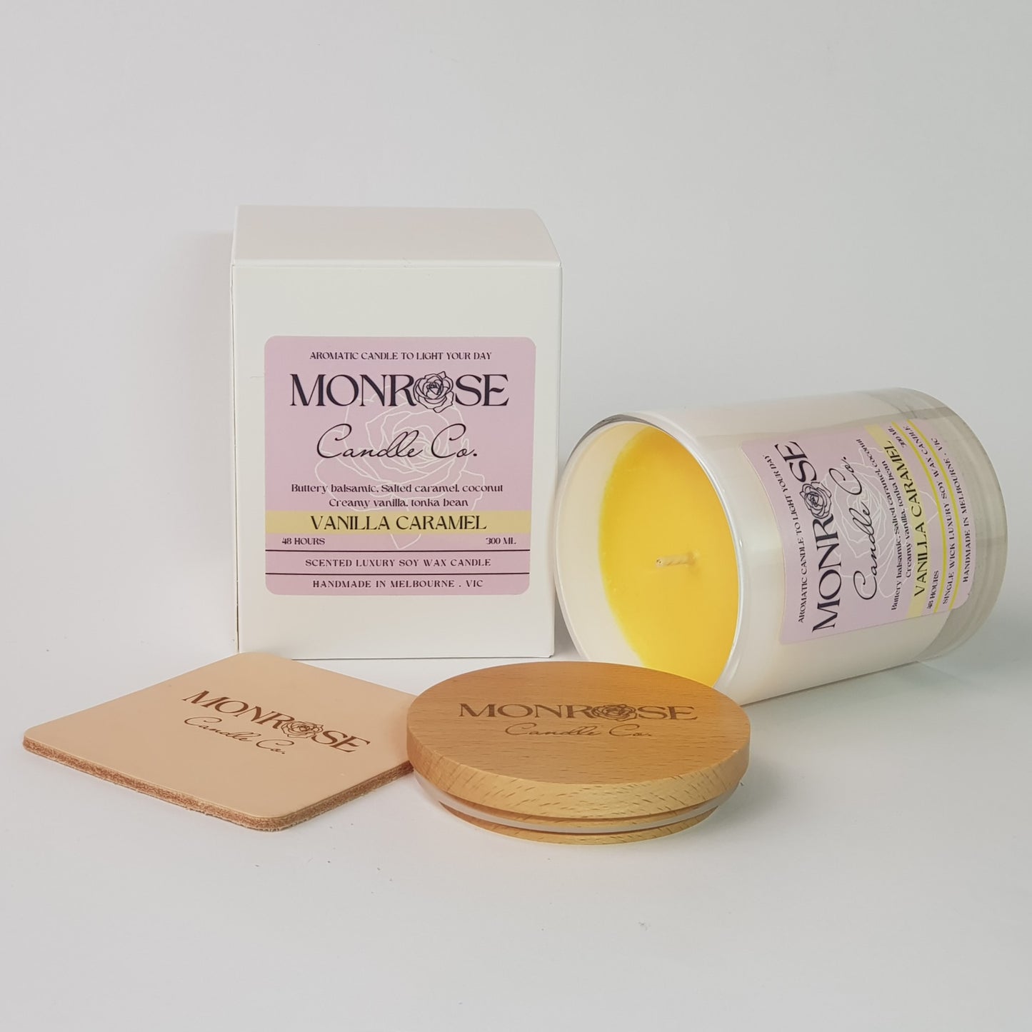 Side view of a white jar candle with "vanilla caramel" fragrance and a cotton wick, containing 265 grams of soy wax and offering 48 hours of burn time.