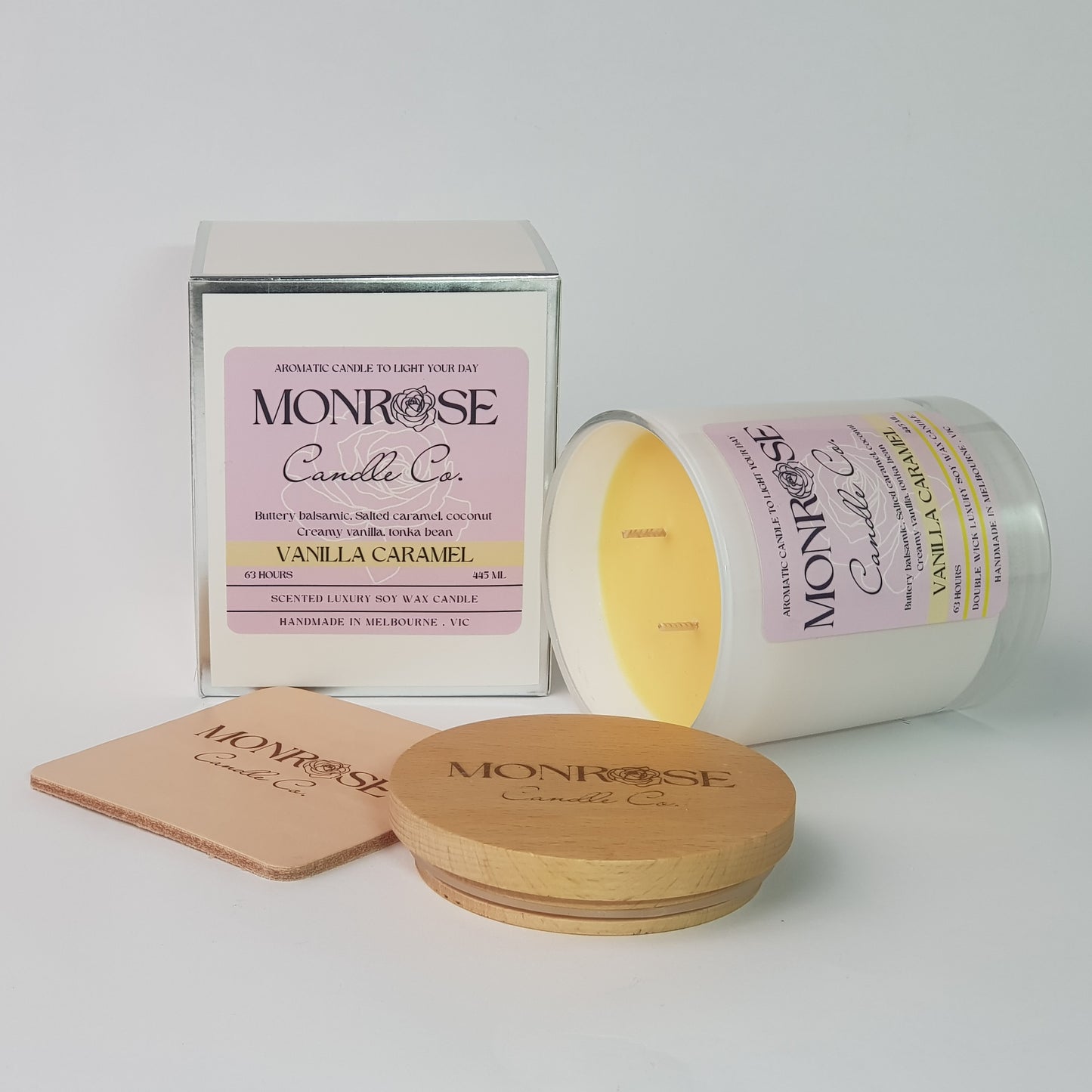 Side view of a white jar candle with "Vanilla caramel" fragrance and double cotton wicks, containing 395 grams of soy wax and offering 63 hours of burn time.