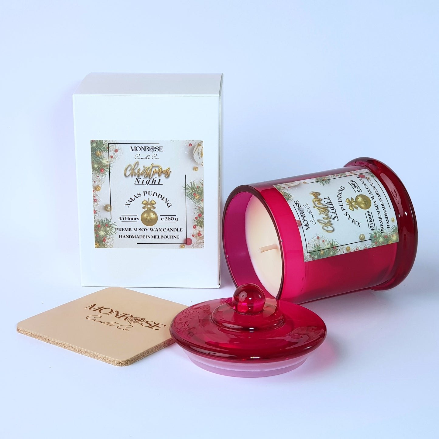 Side view of a scented candle in a red jar with "Christmas Pudding" fragrance and a cotton wick, containing 260 grams of soy wax and offering 45 hours of burn time.