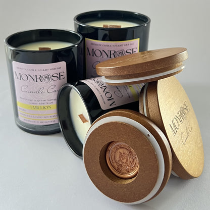 "Front view of 1 million fragrance candle collection in black jars and  wood wicks."