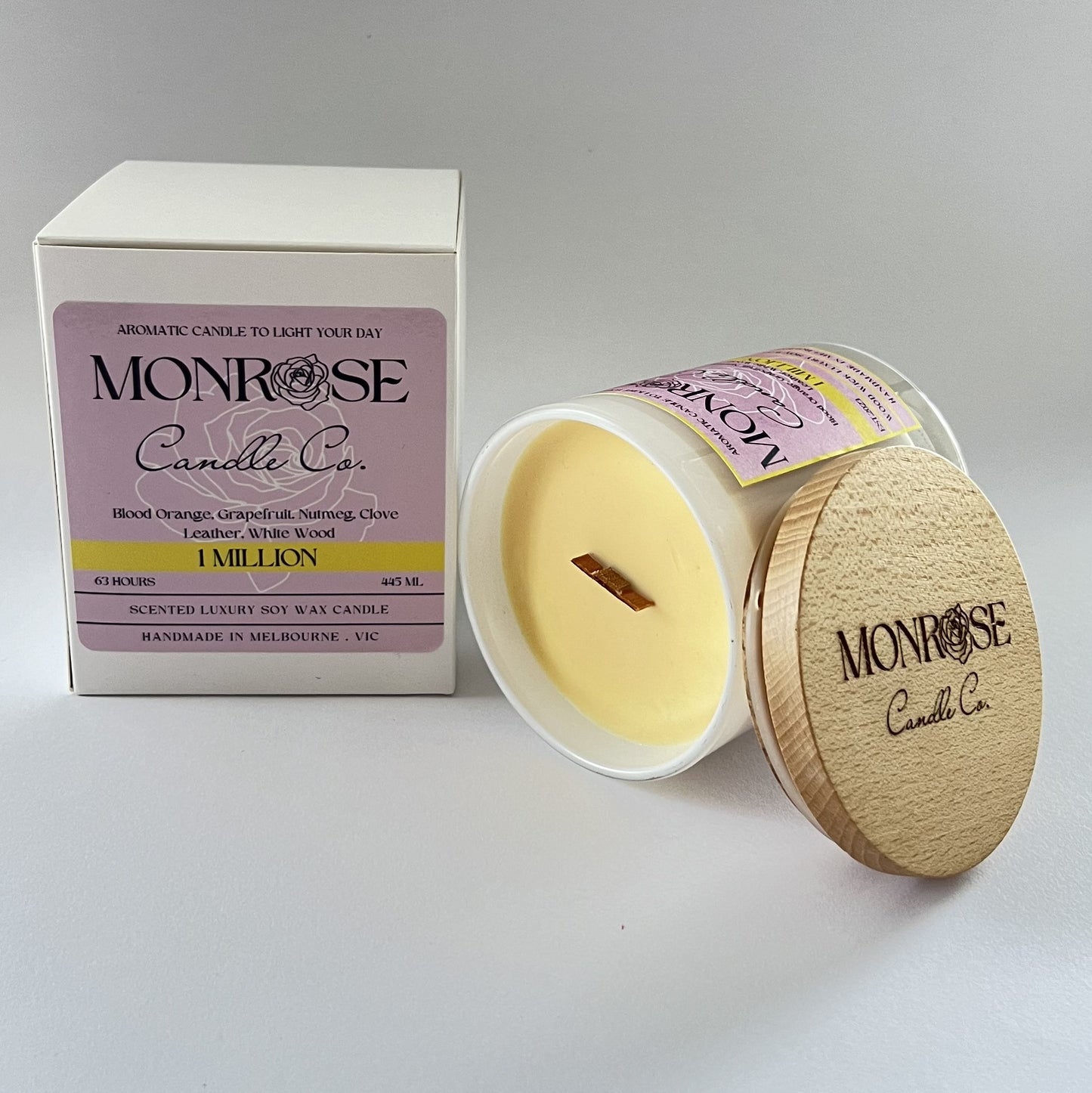 Side view of a white jar candle with "1 million" fragrance and wood wick, containing 385 grams of soy wax and offering 63 hours of burn time.