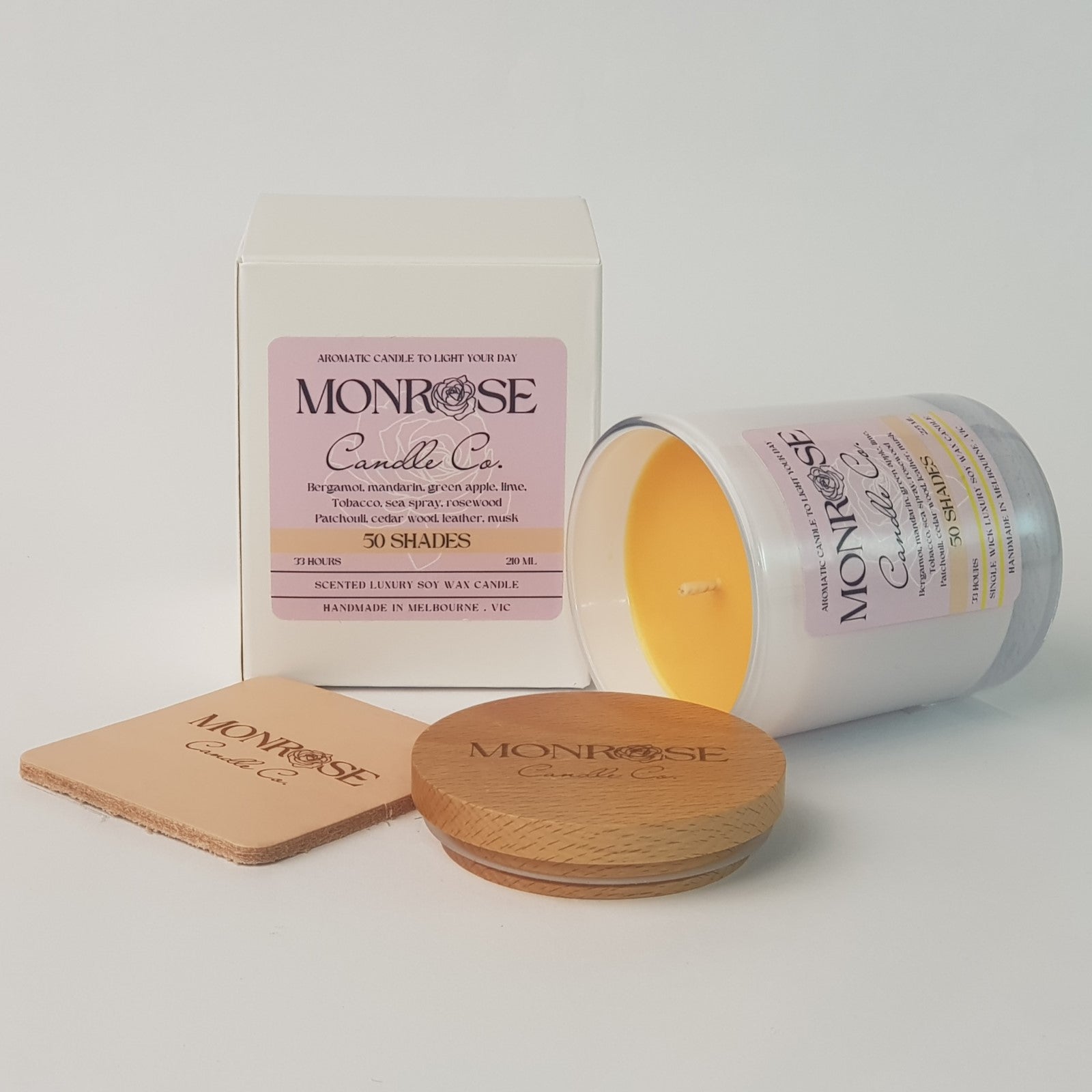 Front view of a white jar candle with "50 Shades" fragrance and a cotton wick, containing 185 grams of soy wax and offering 33 hours of burn time.