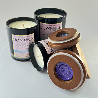Front view of black jar candle collection with "Amour a Paris" fragrance and cotton wick.