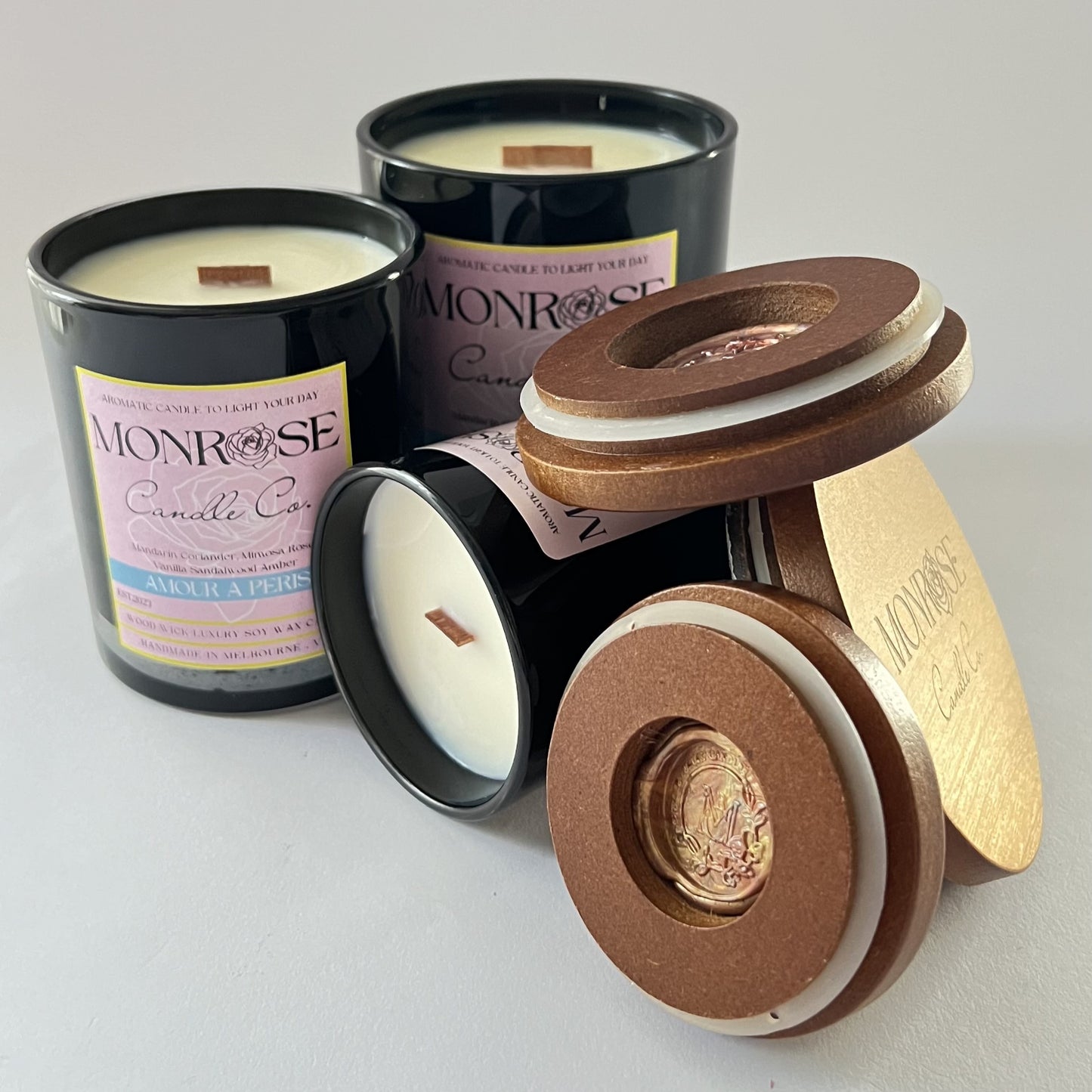Front view of black jar candle collection with "Amour a Paris" fragrance and wood wick.