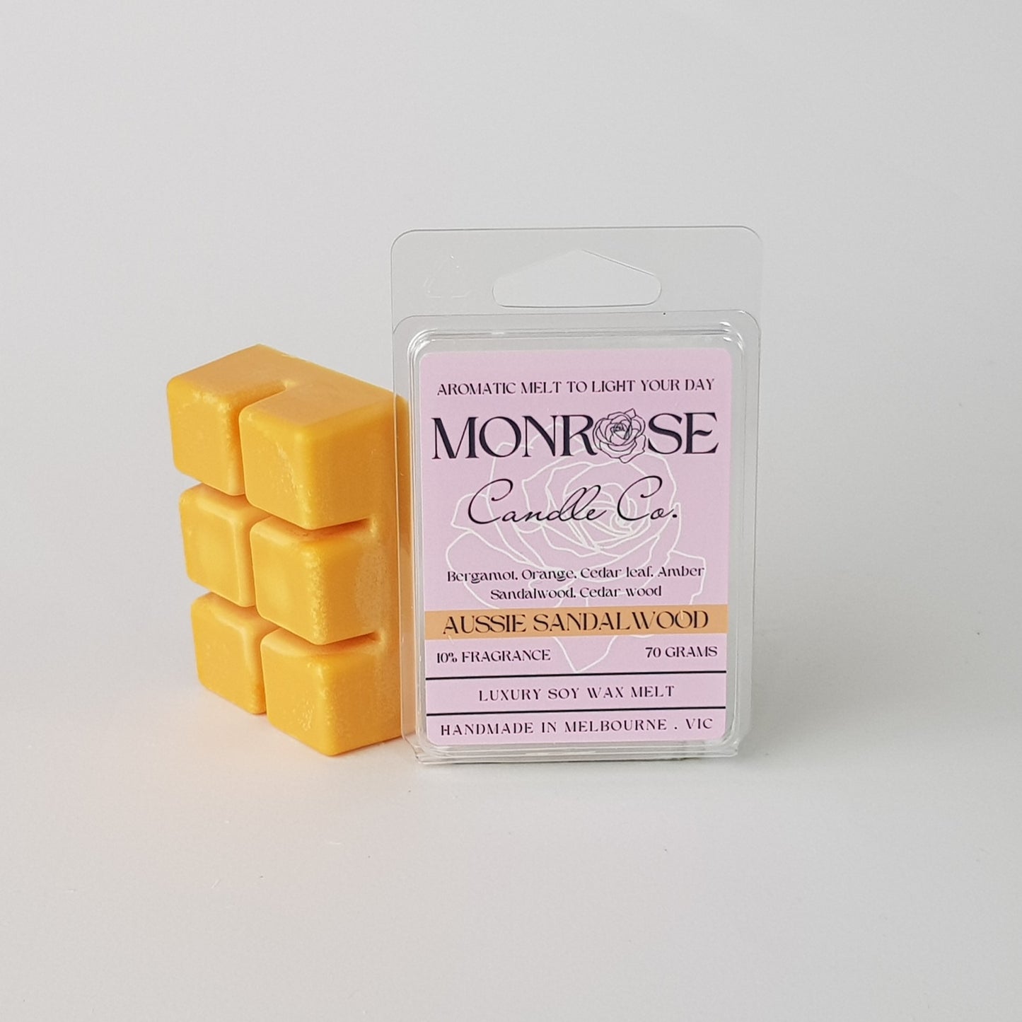 This is the side view of a 6 pack soy wax melt, featuring an orange solid wax melt standing on the left of the packaging. The fragrance of the wax melt is "Australian sandalwood" and contains 70 grams of soy wax and it is hand crafted in Melbourne, Australia.