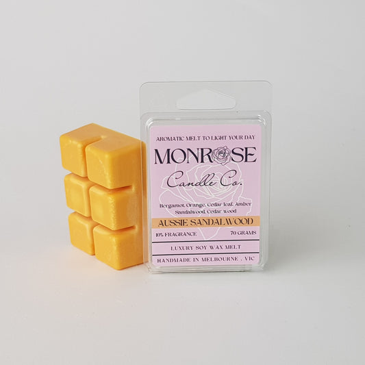This is the side view of a 6 pack soy wax melt, featuring an orange solid wax melt standing on the left of the packaging. The fragrance of the wax melt is "Australian sandalwood" and contains 70 grams of soy wax and it is hand crafted in Melbourne, Australia.