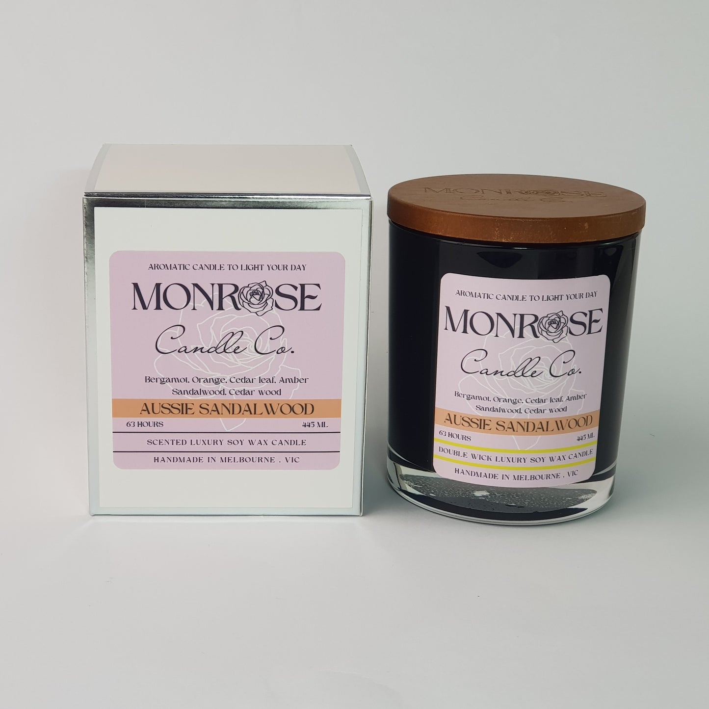 Front view of a container candle with "Australian Sandalwood" fragrance in black glass jar and a cotton wick, containing 395 grams of soy wax and offering 63 hours of burn time.