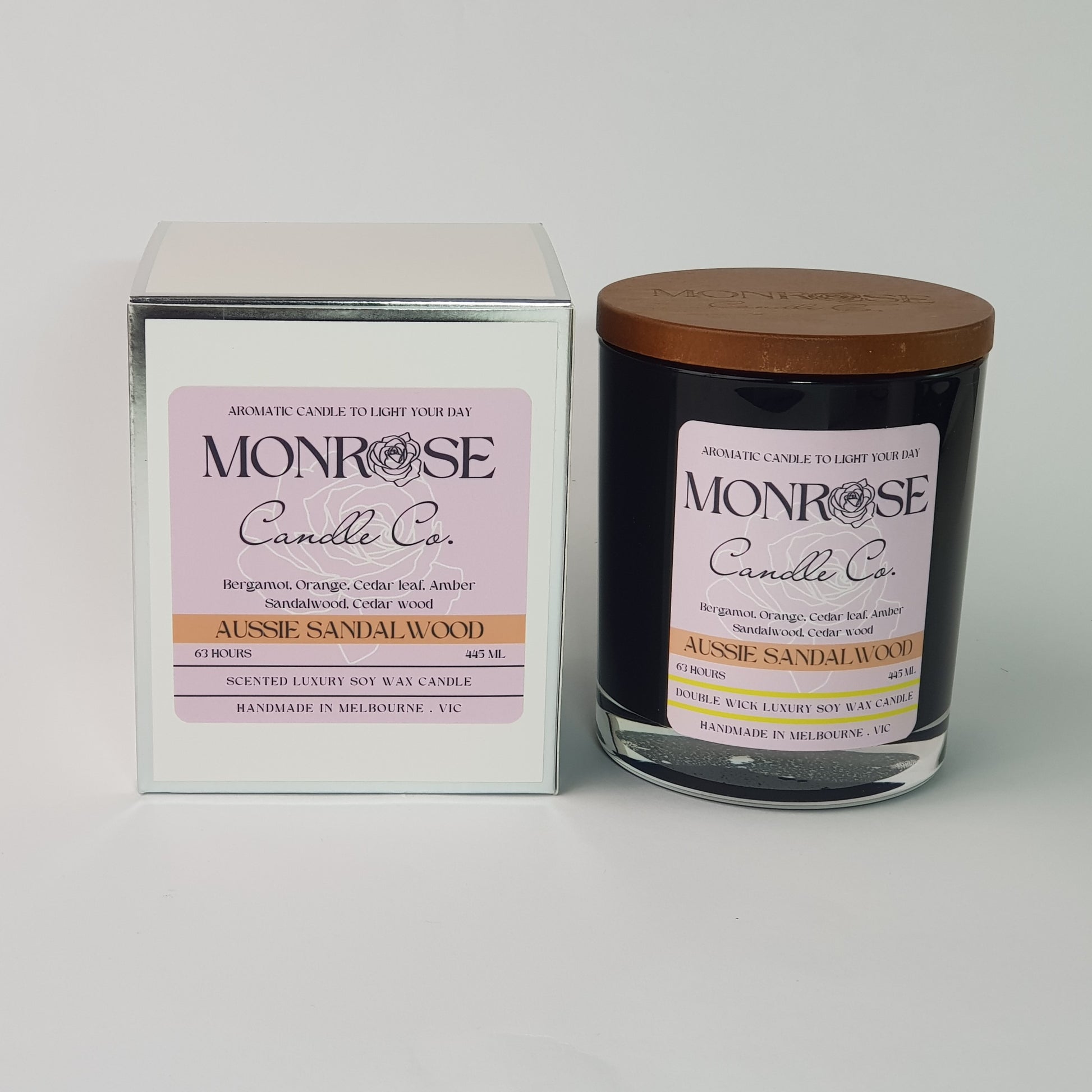Front view of a container candle with "Australian Sandalwood" fragrance in black glass jar and a cotton wick, containing 395 grams of soy wax and offering 63 hours of burn time.