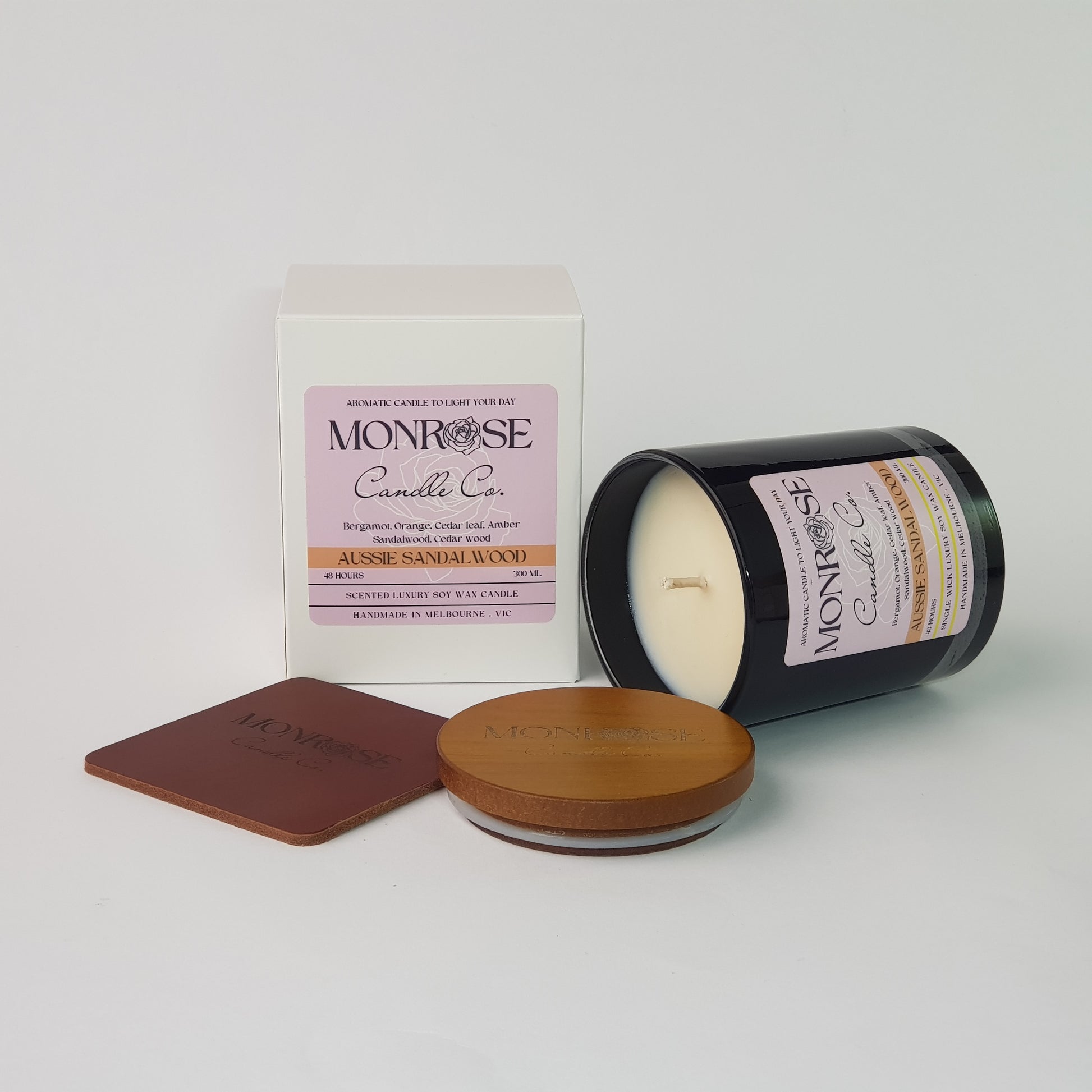 Side view of a container candle with "Australian Sandalwood" fragrance in black glass jar and a cotton wick, containing 265 grams of soy wax and offering 48 hours of burn time.