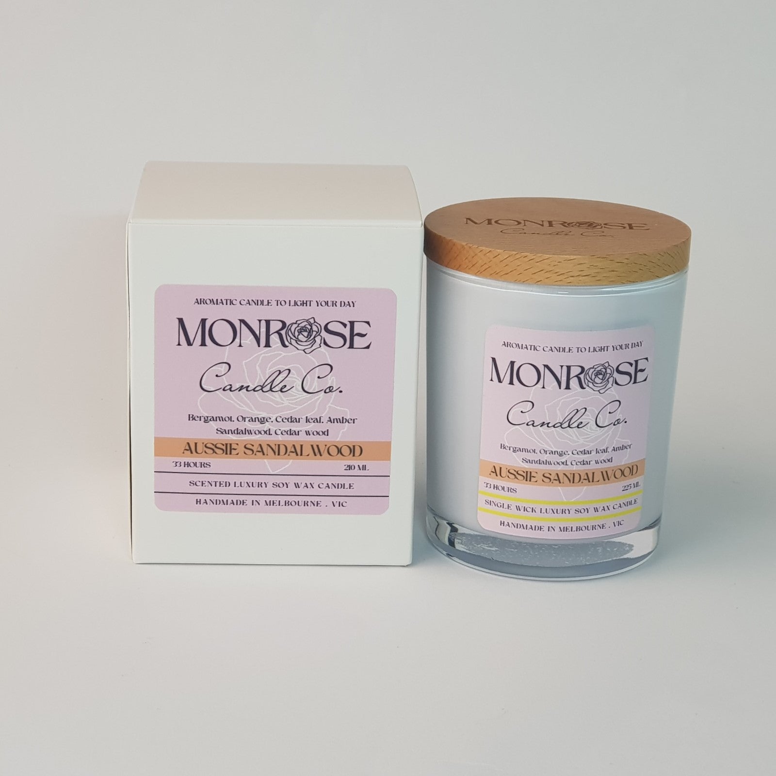 Front view of a container candle with "Australian Sandalwood" fragrance in black glass jar and a cotton wick, containing 185 grams of soy wax and offering 33 hours of burn time.