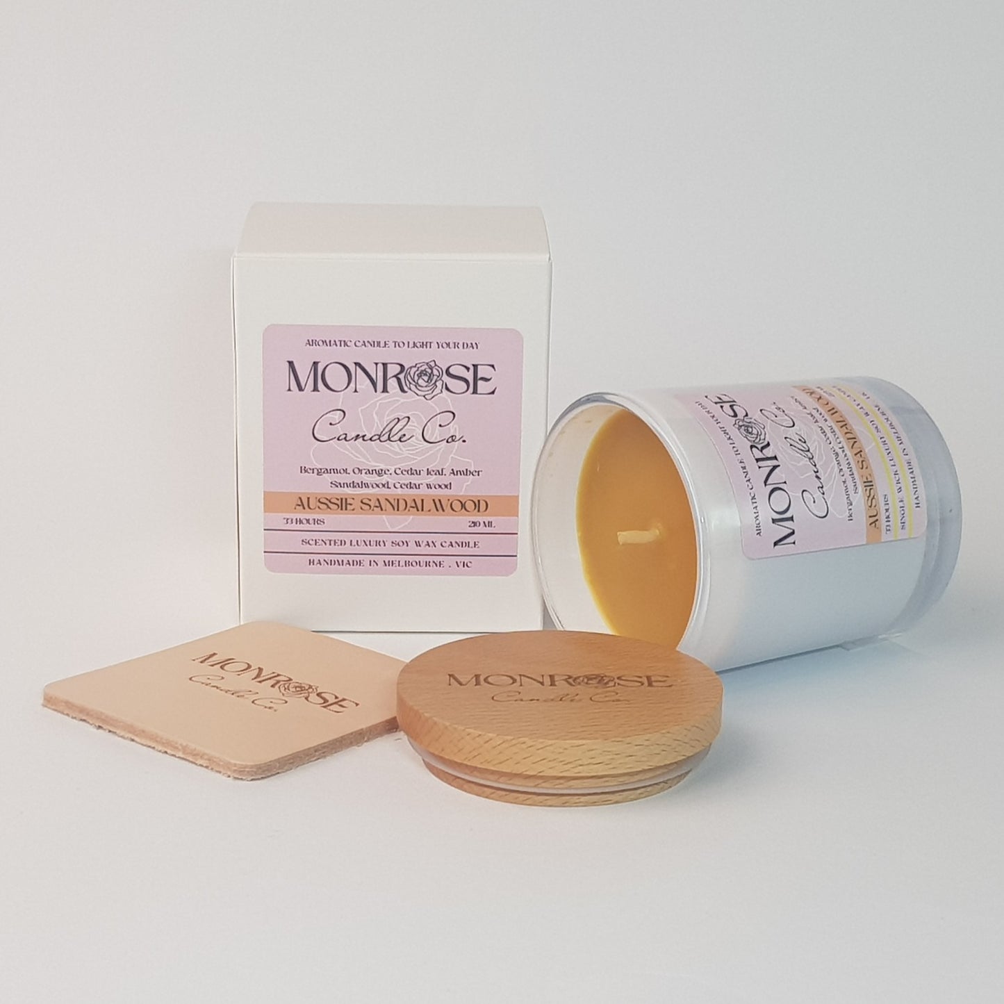 Side view of a container candle with "Australian Sandalwood" fragrance in white glass jar and a cotton wick, containing 185 grams of soy wax and offering 33 hours of burn time.