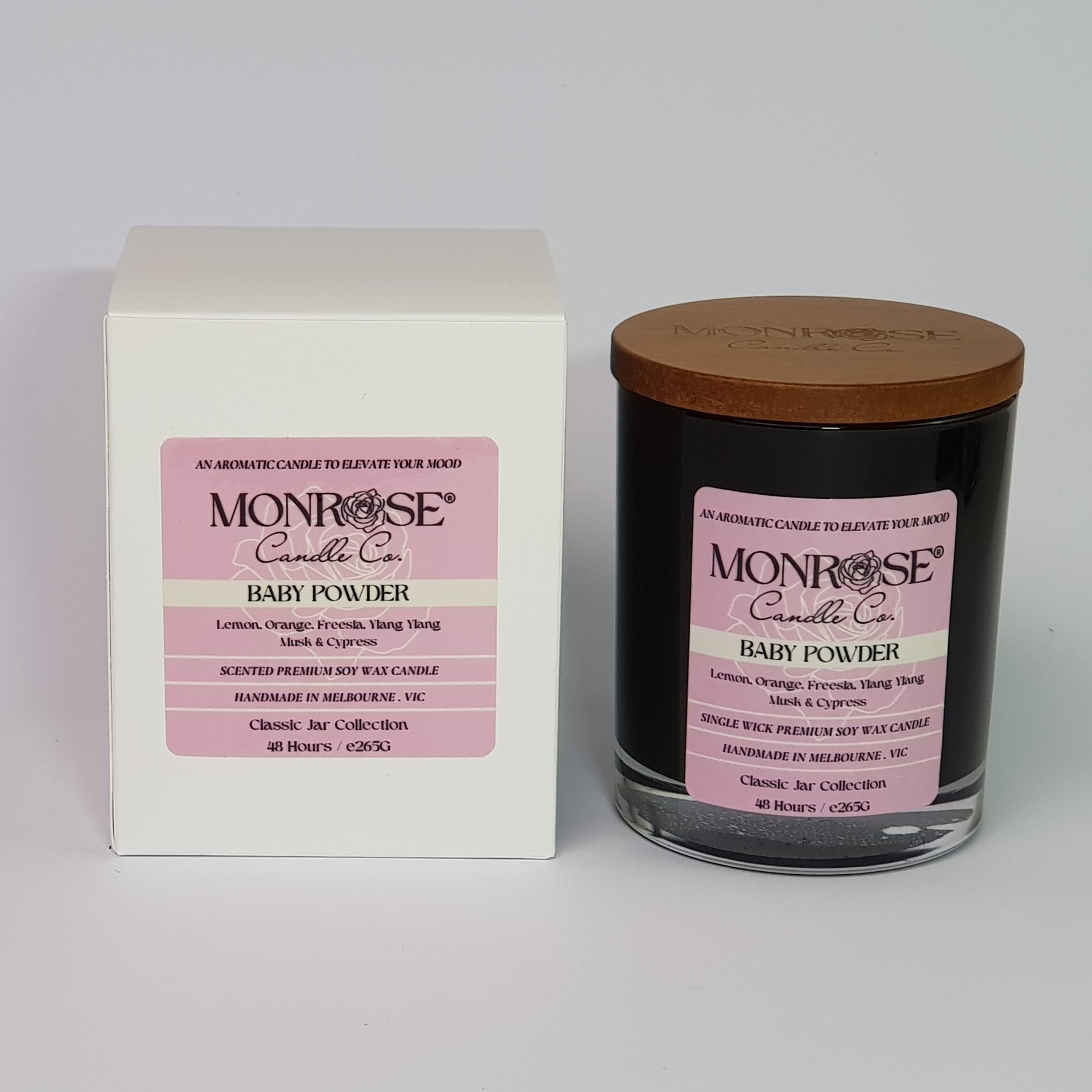 Front view of a black jar candle with "Baby powder" fragrance and a cotton wick, containing 265 grams of soy wax and offering 48 hours of burn time.