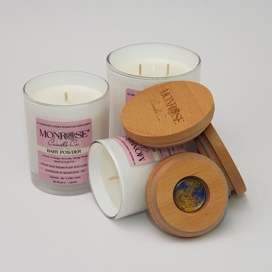 Front view of a candle collection in White jars with "Baby powder" fragrance and a cotton wick.