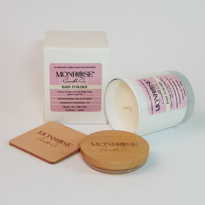 Side view of a white jar candle with "Baby Powder" fragrance and double cotton wick, containing 185 grams of soy wax and offering 33 hours of burn time.