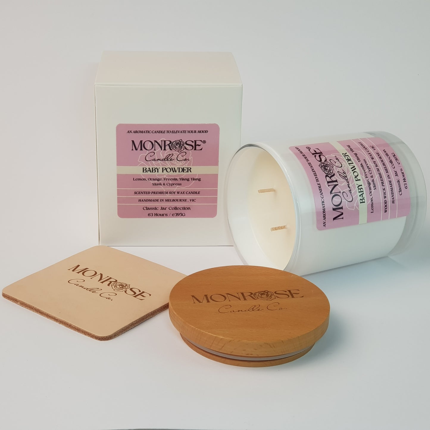 Side view of a white jar candle with "Baby powder" fragrance and double cotton wicks, containing 395 grams of soy wax and offering 63 hours of burn time.