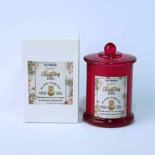 This is a front view of a red jar candle with "Black currant" fragrance and a cotton wick, containing 160 grams of soy wax and offering 30 hours of burn time.