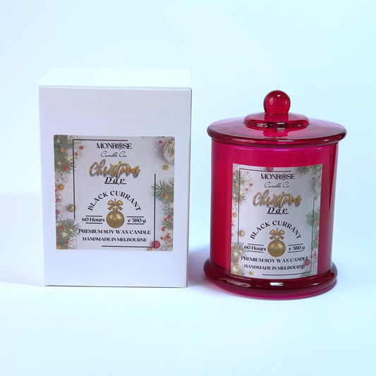 Front view of a red jar candle with 
"Black Currant" fragrance and a cotton wick, containing 380 grams of soy wax and offering 60 hours of burn time.