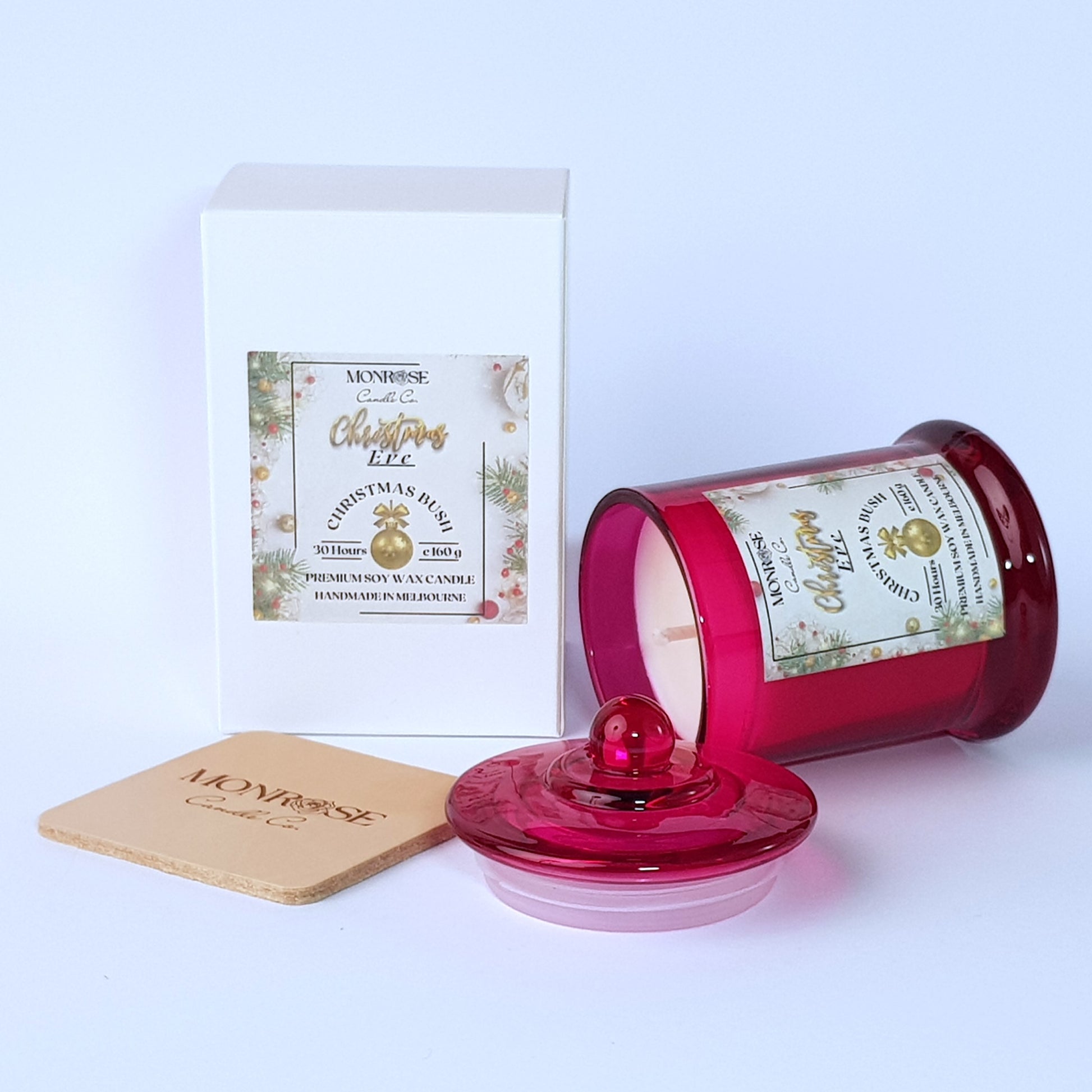 This is a side view of a red jar candle with "Christmas bush" fragrance and a cotton wick, containing 160 grams of soy wax and offering 30 hours of burn time.