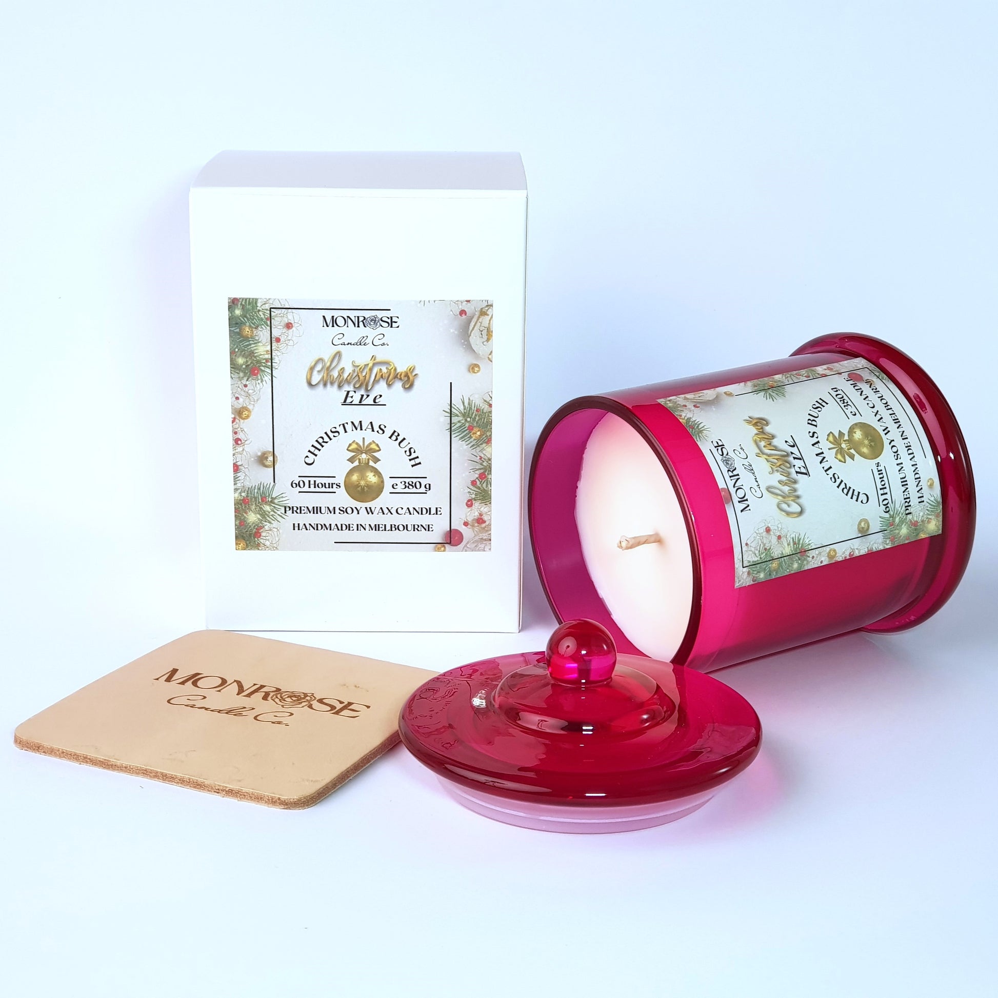 This is a side view of a red jar candle with "Christmas bush" fragrance and a cotton wick, containing 380 grams of soy wax and offering 60 hours of burn time.