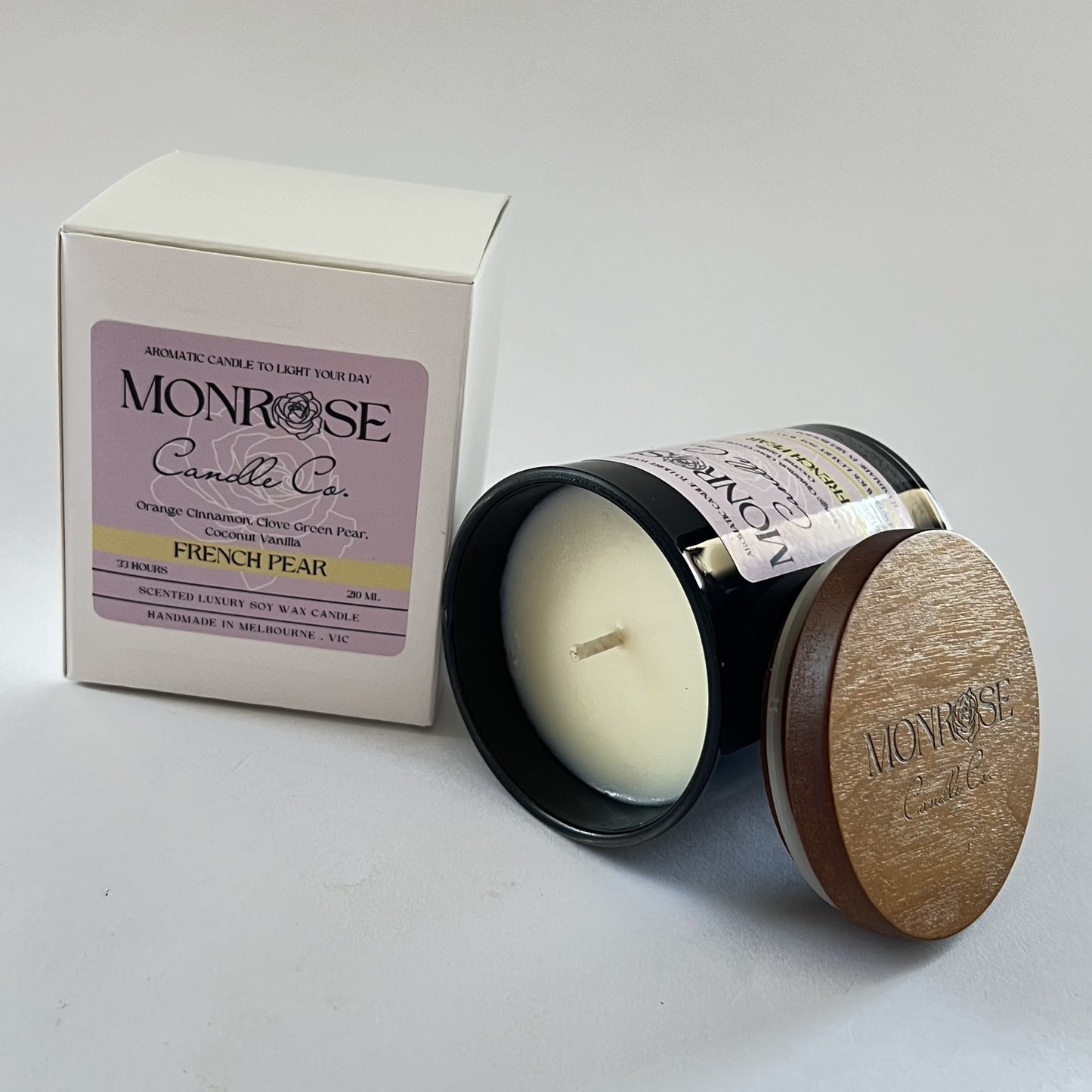 "Side view of a black jar candle with French pear fragrance and cotton wick, containing 165 grams of soy wax and offering 33 hours of burn time."