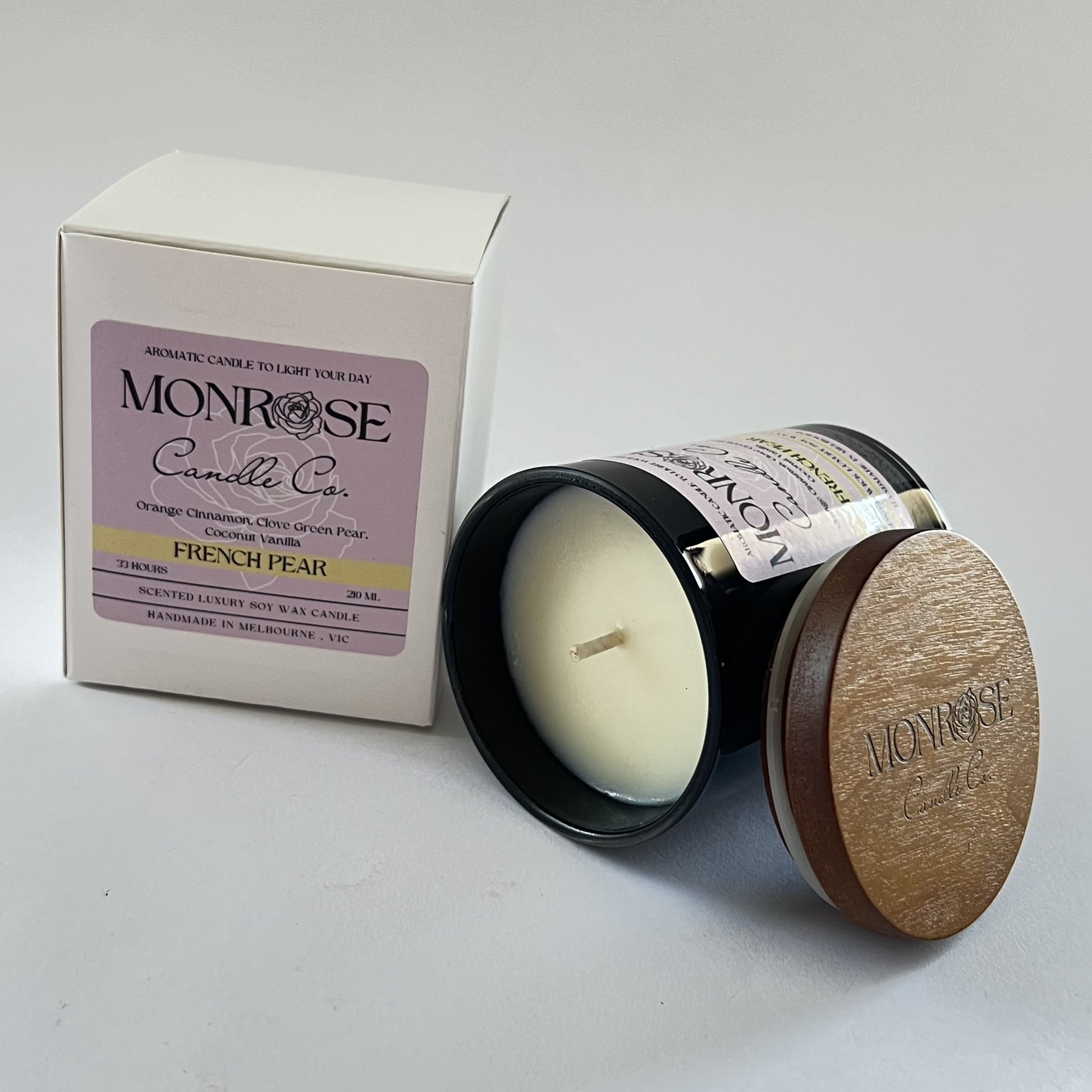 "Side view of a black jar candle with French pear fragrance and cotton wick, containing 165 grams of soy wax and offering 33 hours of burn time."