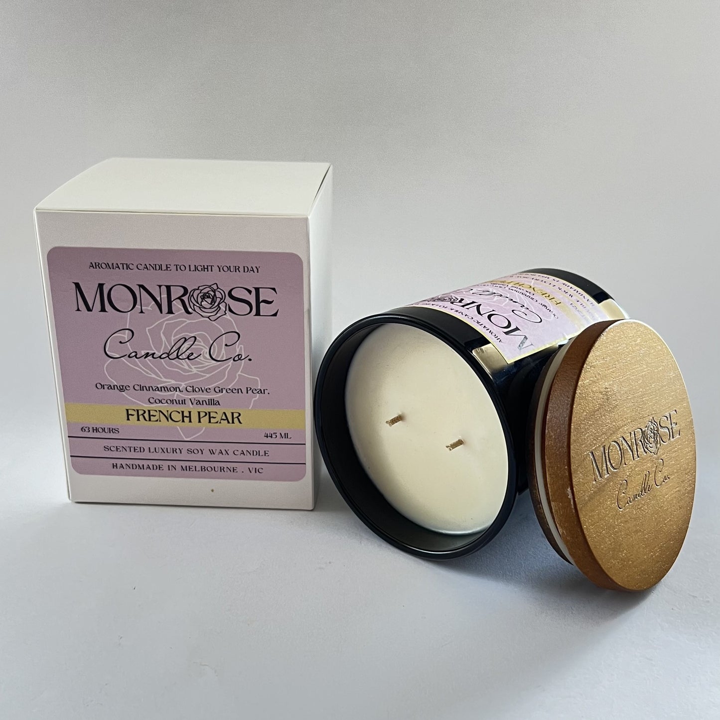 "Side view of a black jar candle with French pear fragrance and double cotton wicks, containing 395 grams of soy wax and offering 63 hours of burn time."