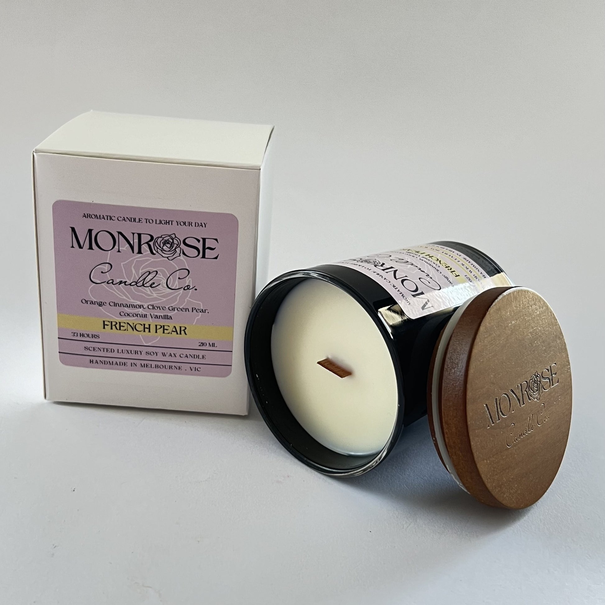 "Side view of a black jar candle with French pear fragrance and wood wick, containing 185 grams of soy wax and offering 33 hours of burn time."