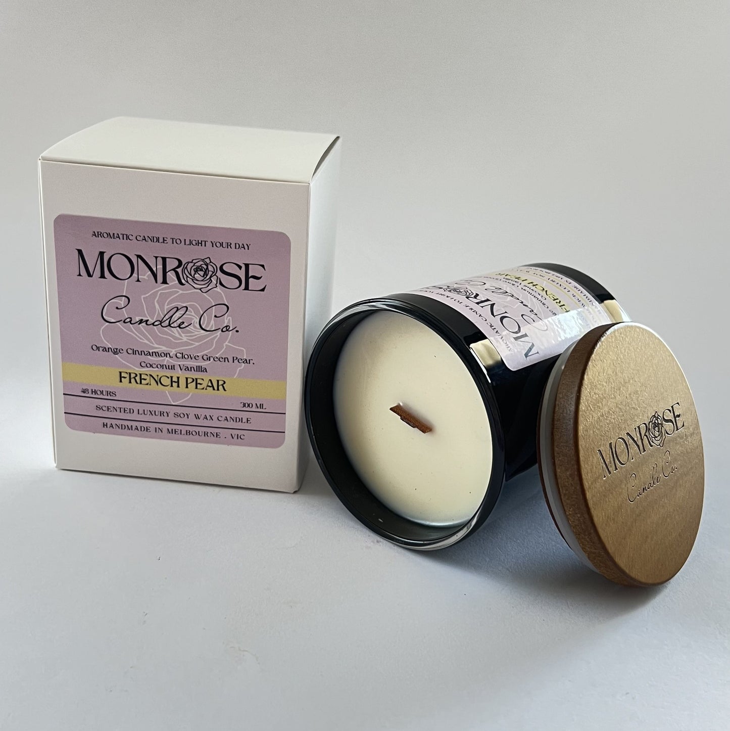 "Side view of a black jar candle with French pear fragrance and wood wick, containing 265 grams of soy wax and offering 48 hours of burn time."