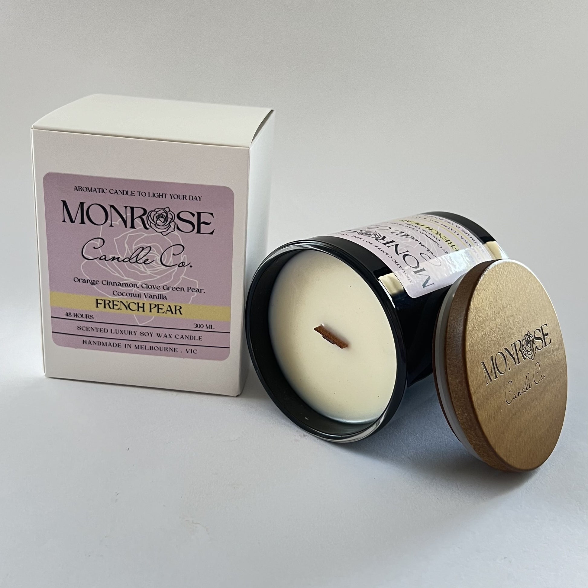 "Side view of a black jar candle with French pear fragrance and wood wick, containing 265 grams of soy wax and offering 48 hours of burn time."