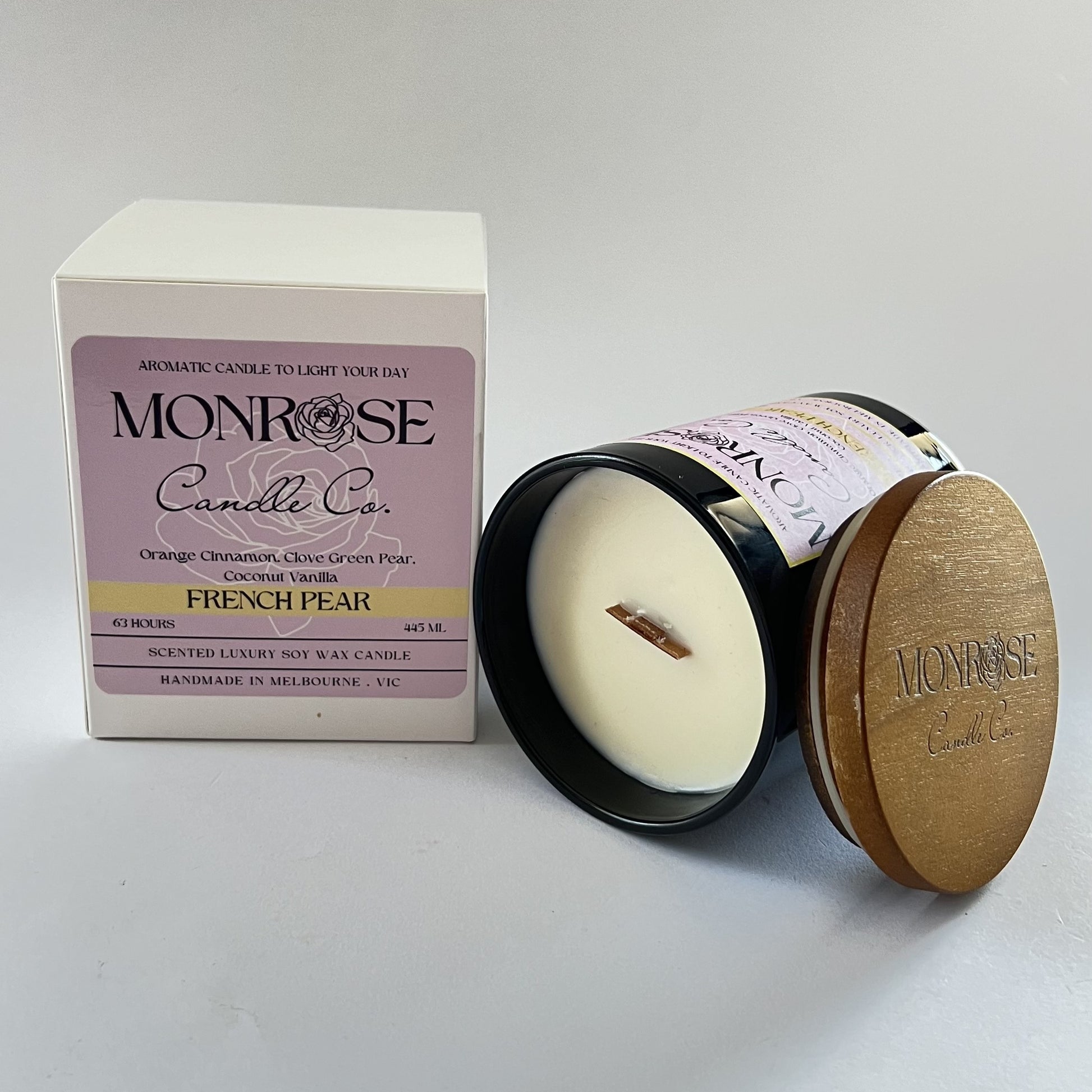 "Side view of a black jar candle with French pear fragrance and wood wick, containing 395 grams of soy wax and offering 63 hours of burn time."