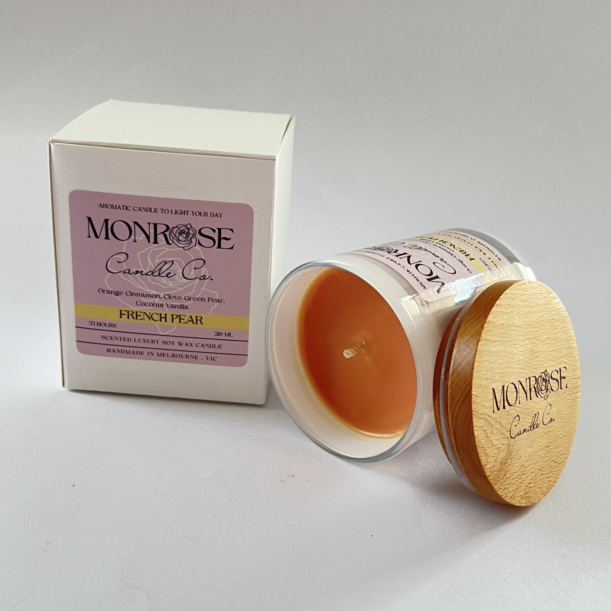 Side view of a white jar candle with "French pear" fragrance and double cotton wicks, containing 185 grams of soy wax and offering 33 hours of burn time.